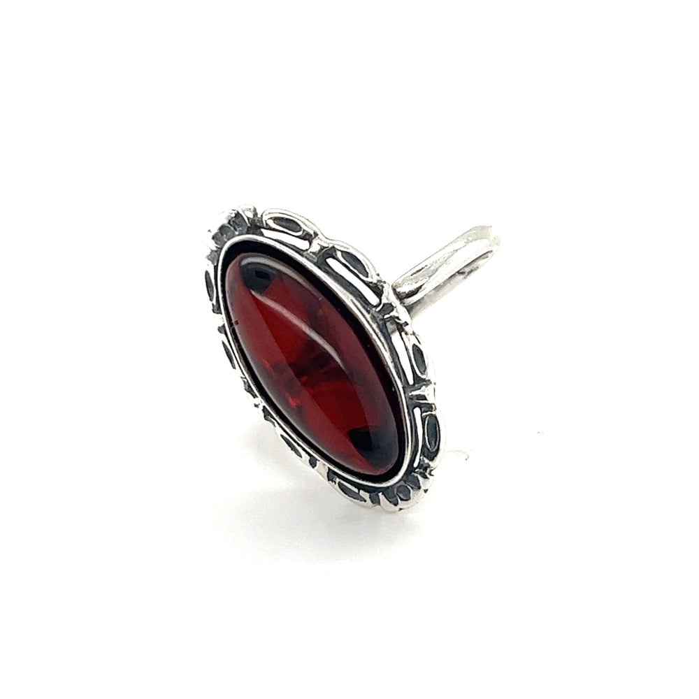An oval red Enchanting Adjustable Baltic Cherry Amber Ring with a detailed sterling silver setting on a white background.