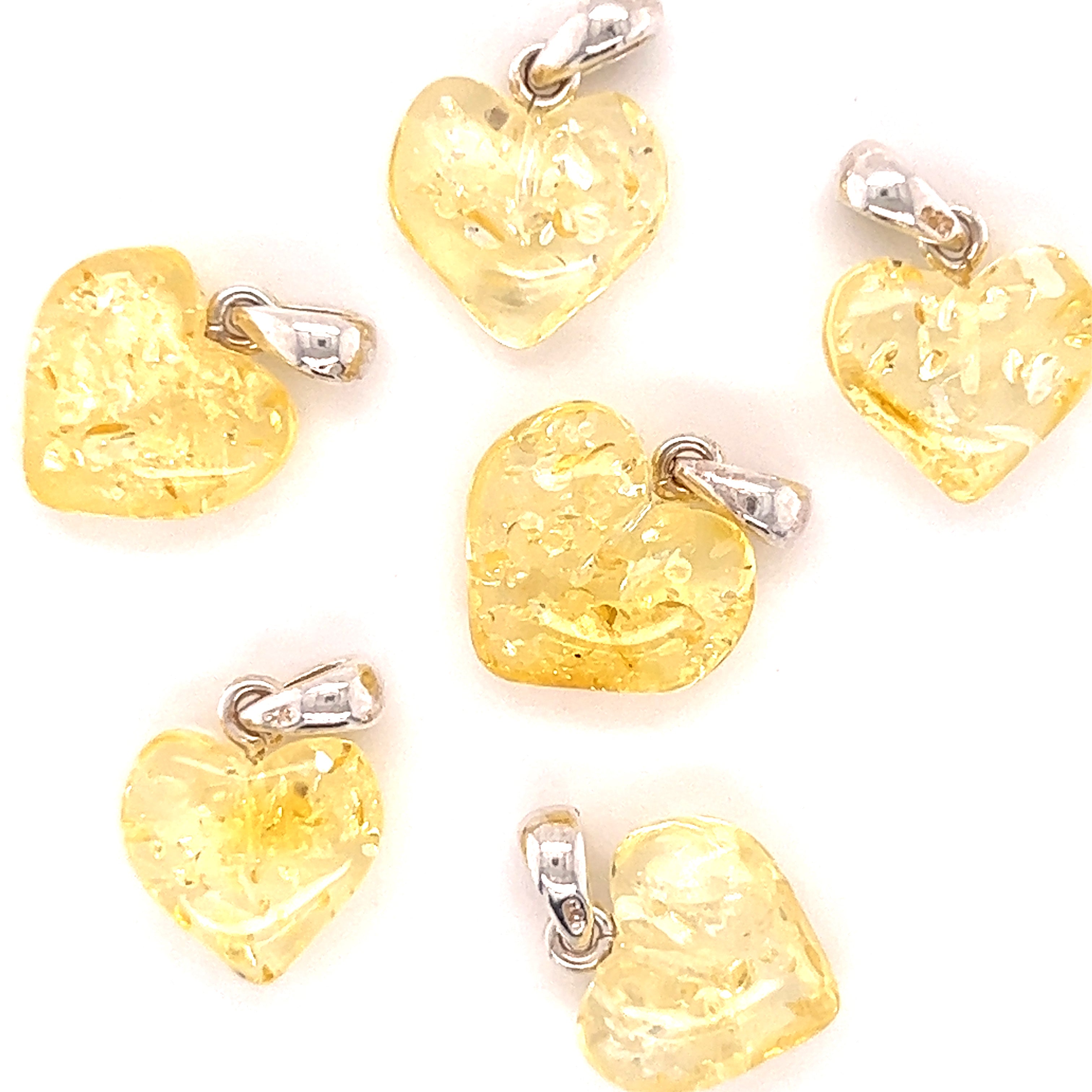Six yellow glass heart shaped Charming Baltic Amber Heart Pendants with Baltic amber detail on a white background, from the Super Silver brand.