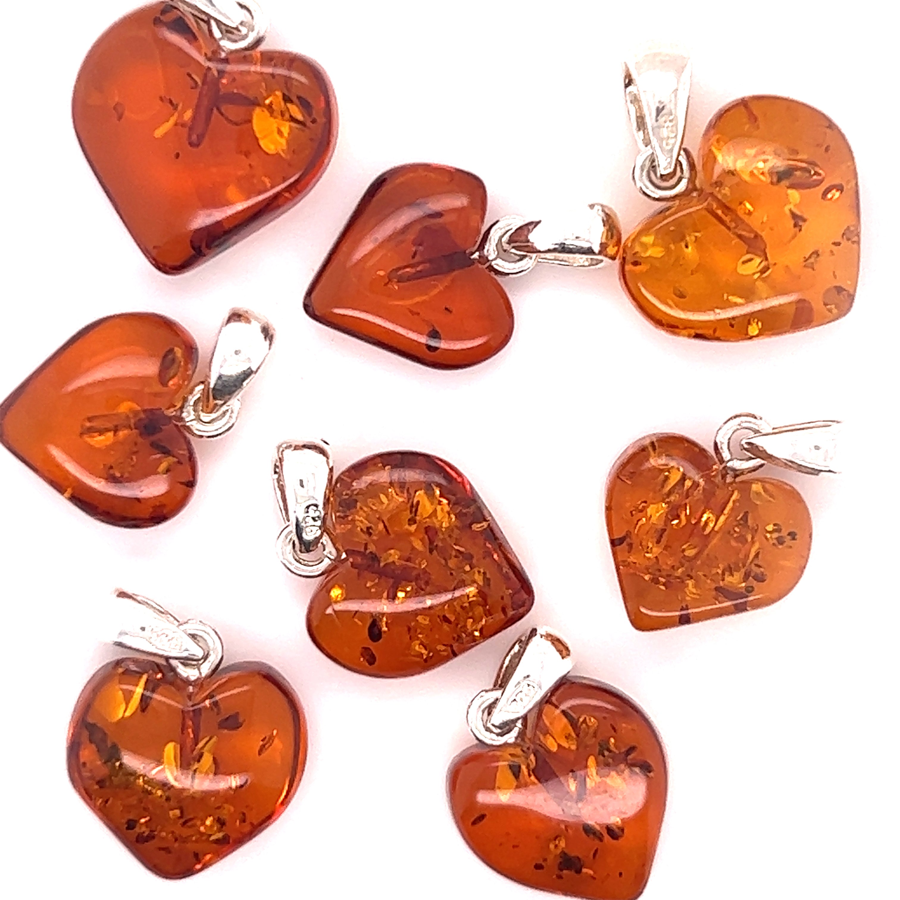 A group of Charming Baltic Amber Heart Pendants, each featuring a heart shape and crafted with .925 Sterling Silver, from the brand Super Silver.