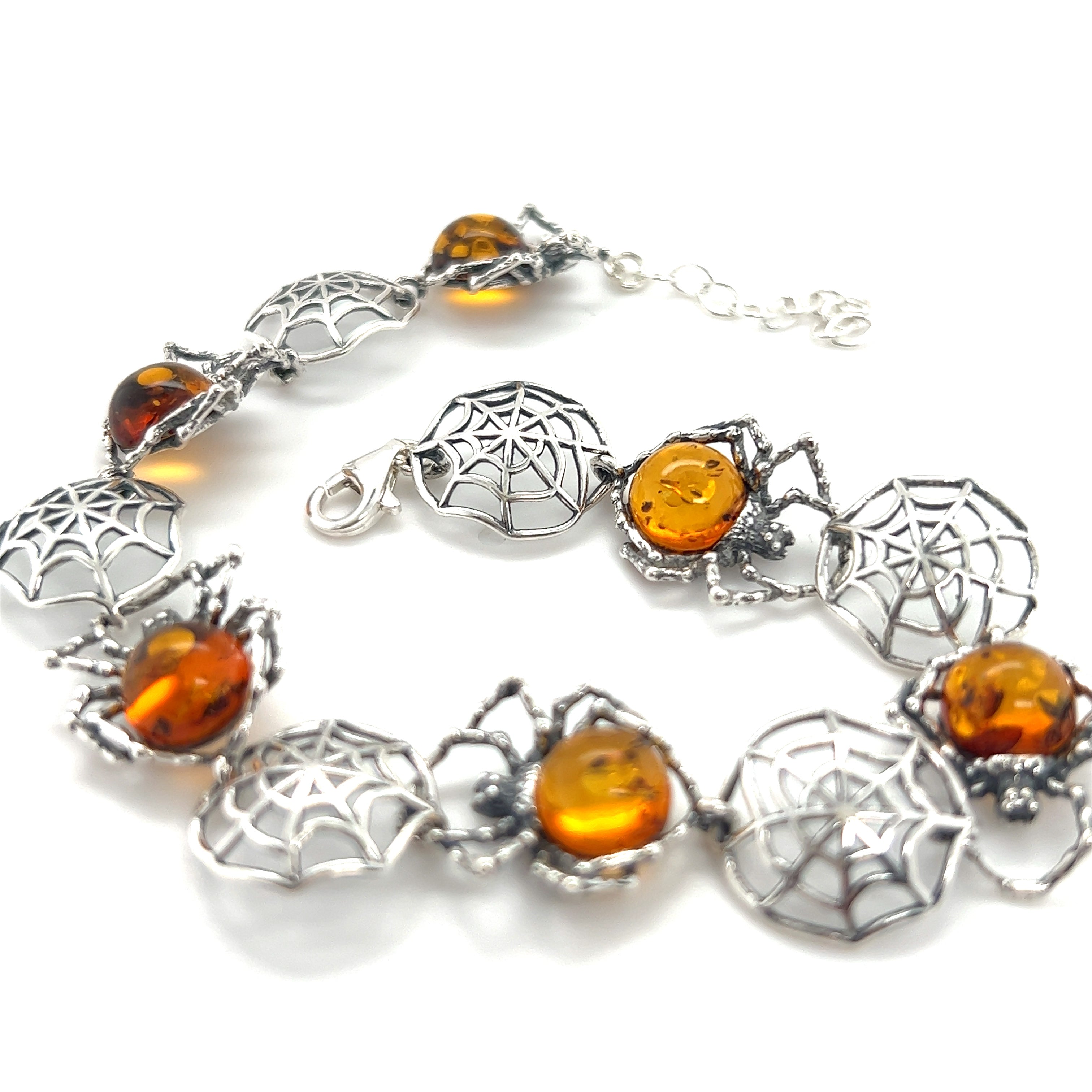 A stunning Spellbinding Amber Spider Bracelet adorned with Super Silver silverwork details and accented with amber beads.