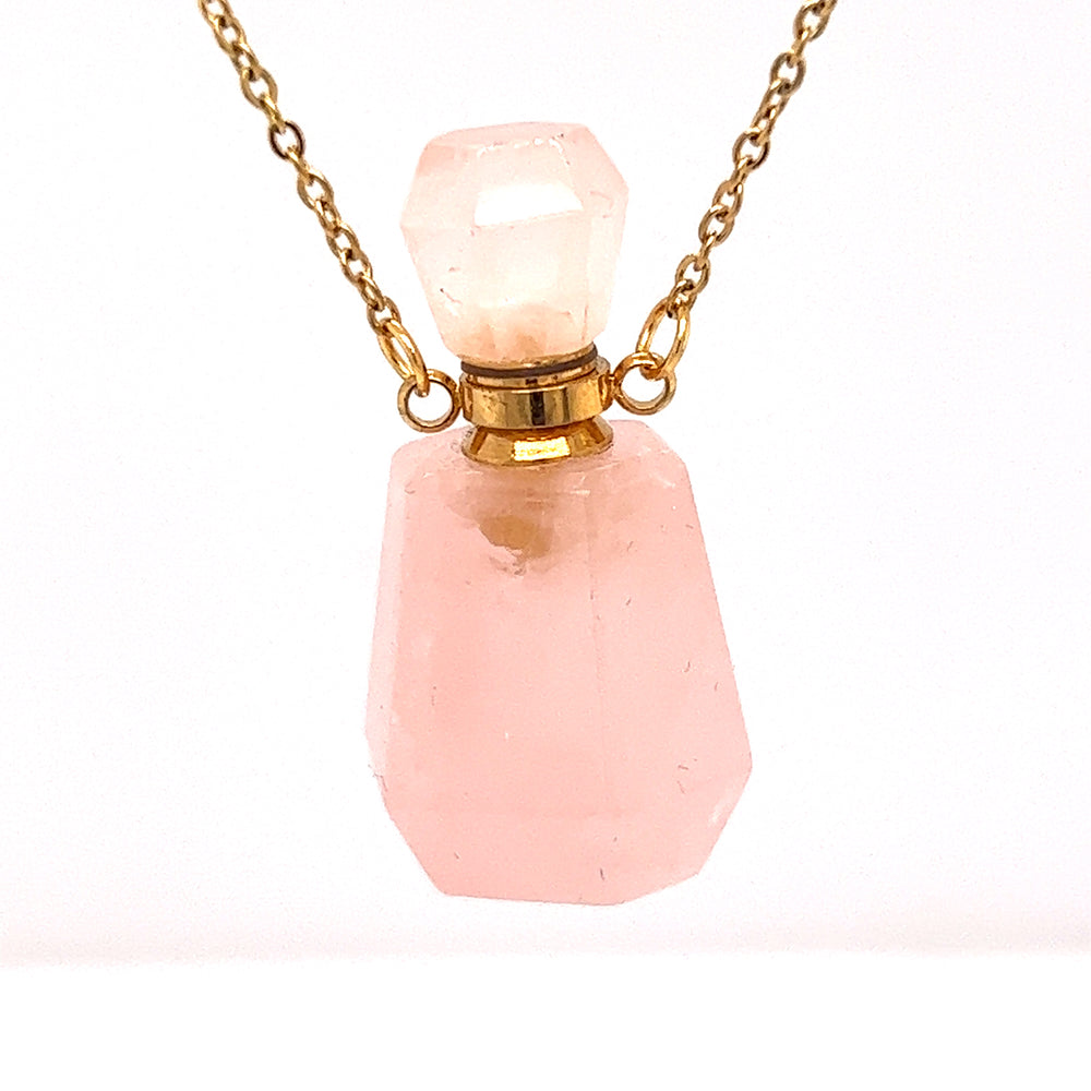 
                  
                    A Crystal Perfume Vial Necklace on a gold chain, featuring a pink quartz stone by Super Silver.
                  
                