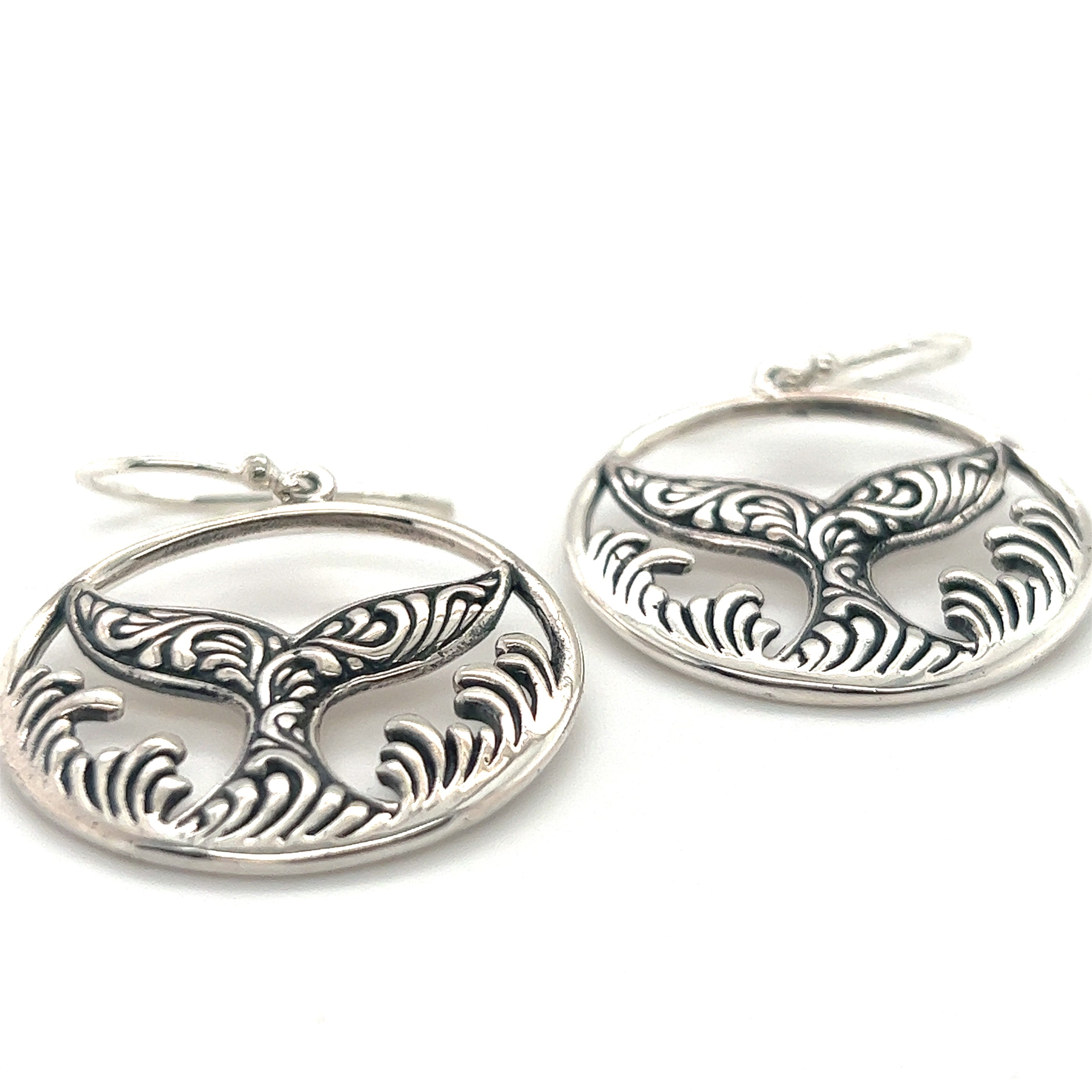 A pair of Enchanting Filigree Whale Tail Earrings by Super Silver, with a wave design, inspired by the majestic ocean waves of Santa Cruz.