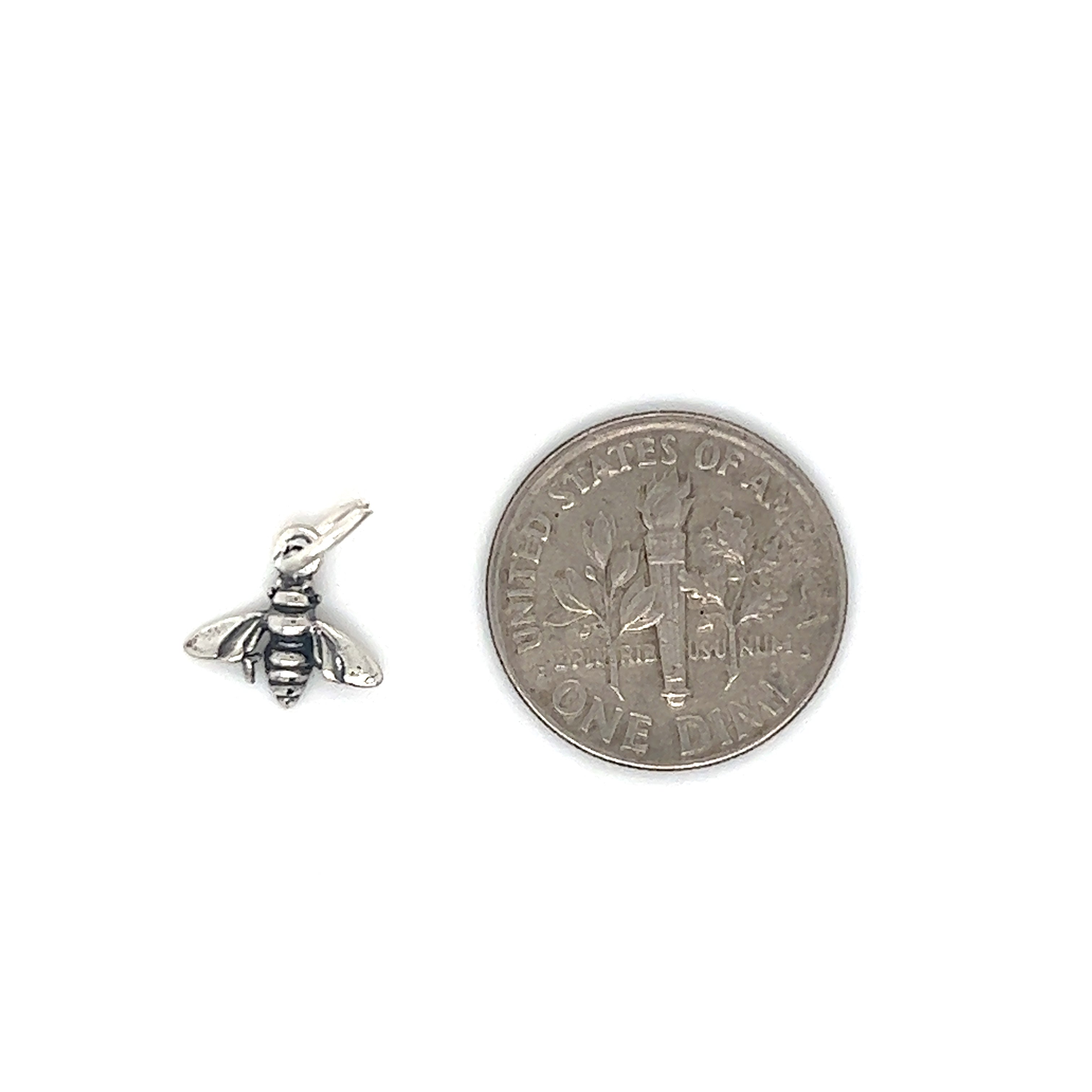 A Super Silver Tiny Bee Charm sits next to a penny.