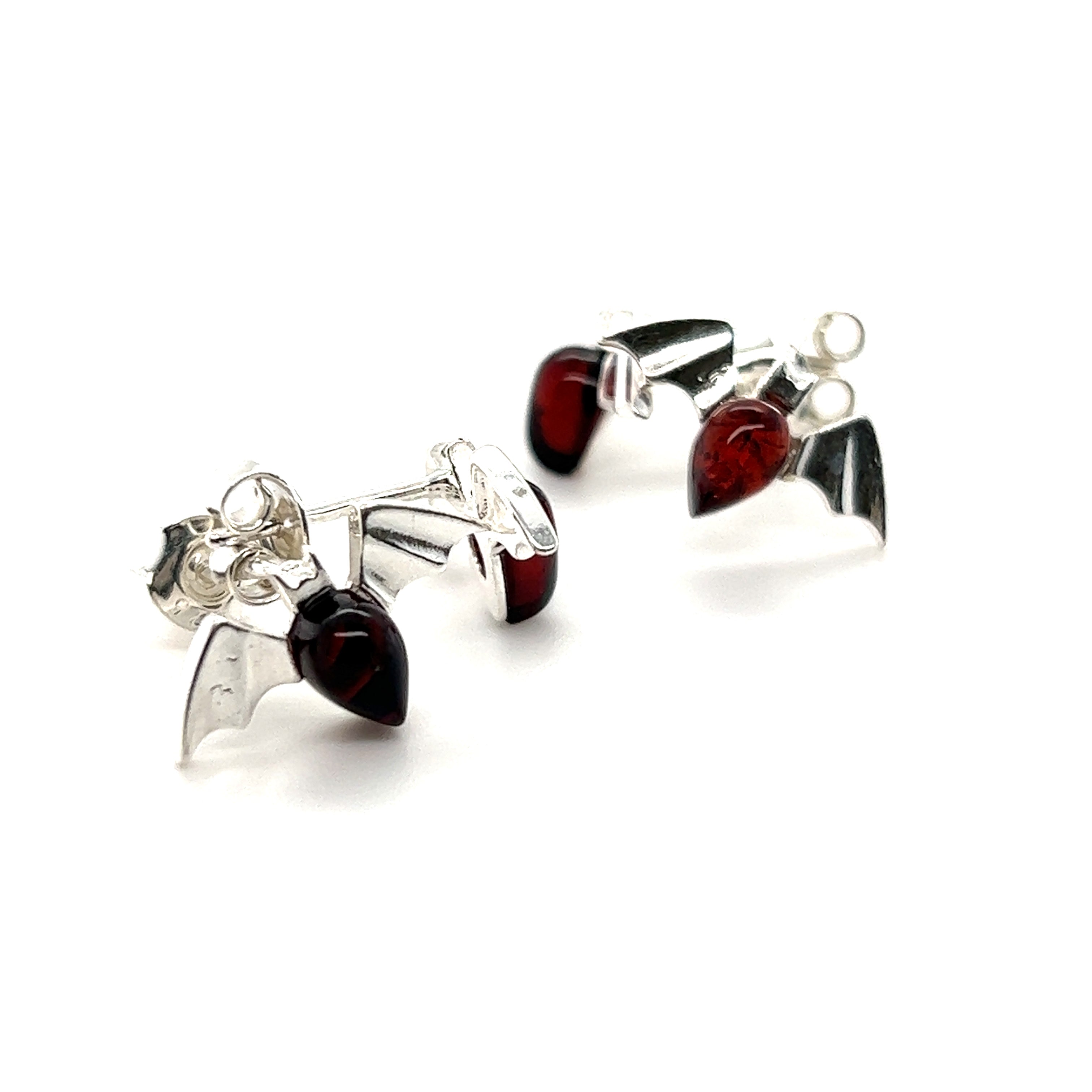 A pair of Enchanting Baltic Amber Bat Stud Earrings with red stones in Super Silver.