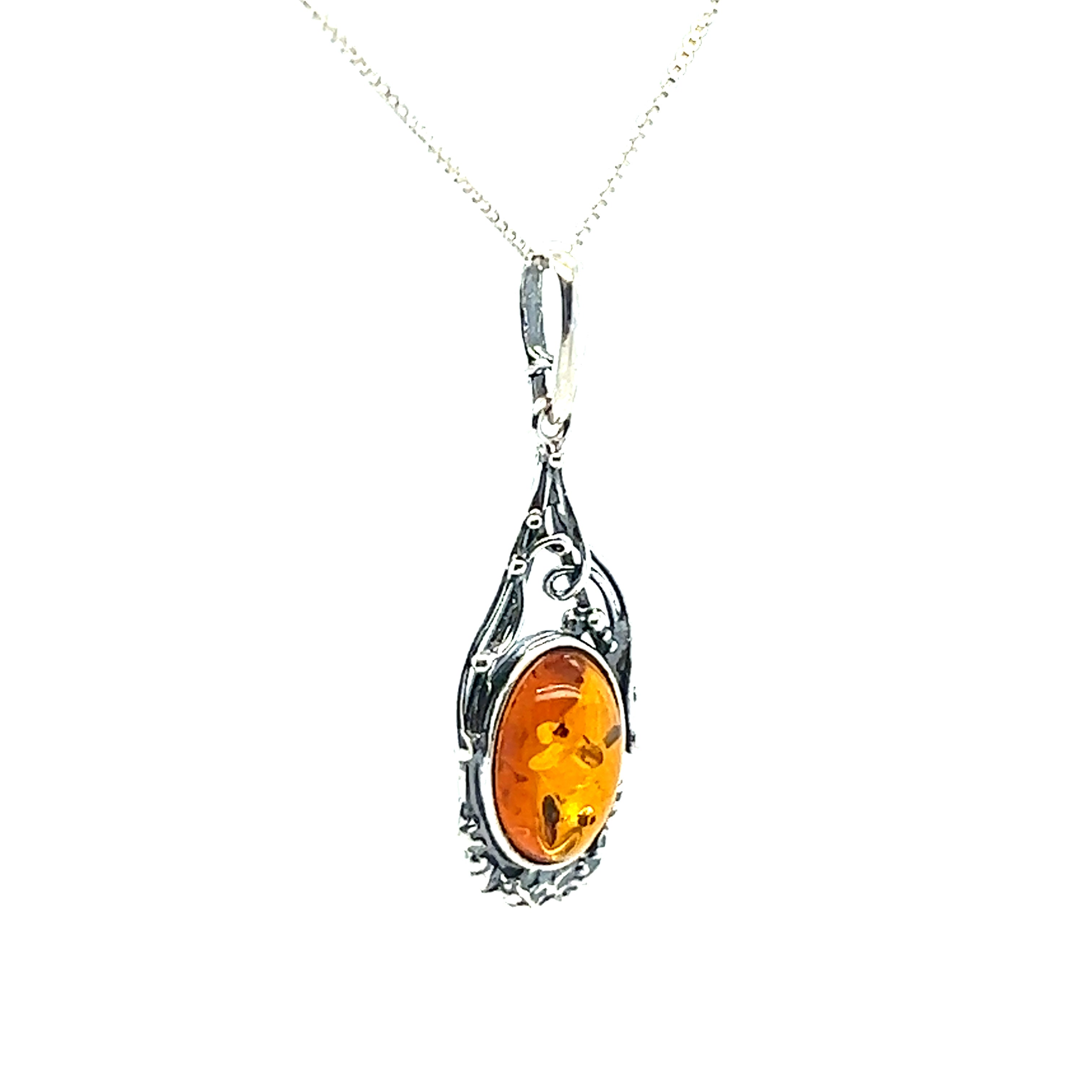 A Super Silver Antique Style Amber Pendant with an orange amber stone.