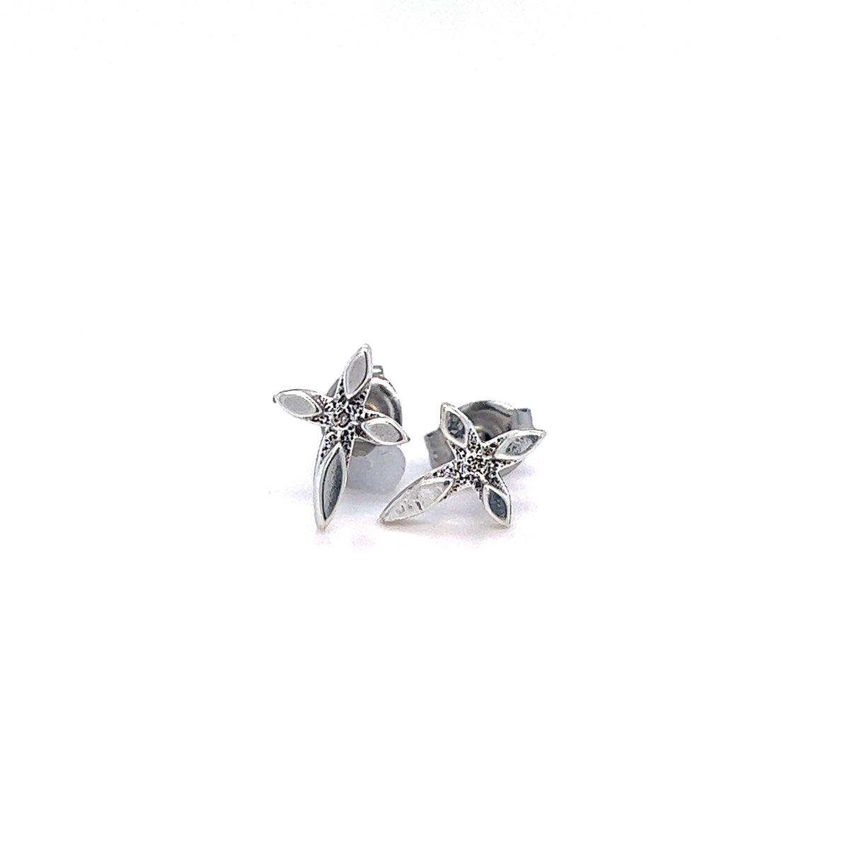 A pair of Delicate Cross Studs by Super Silver on a chic white surface.