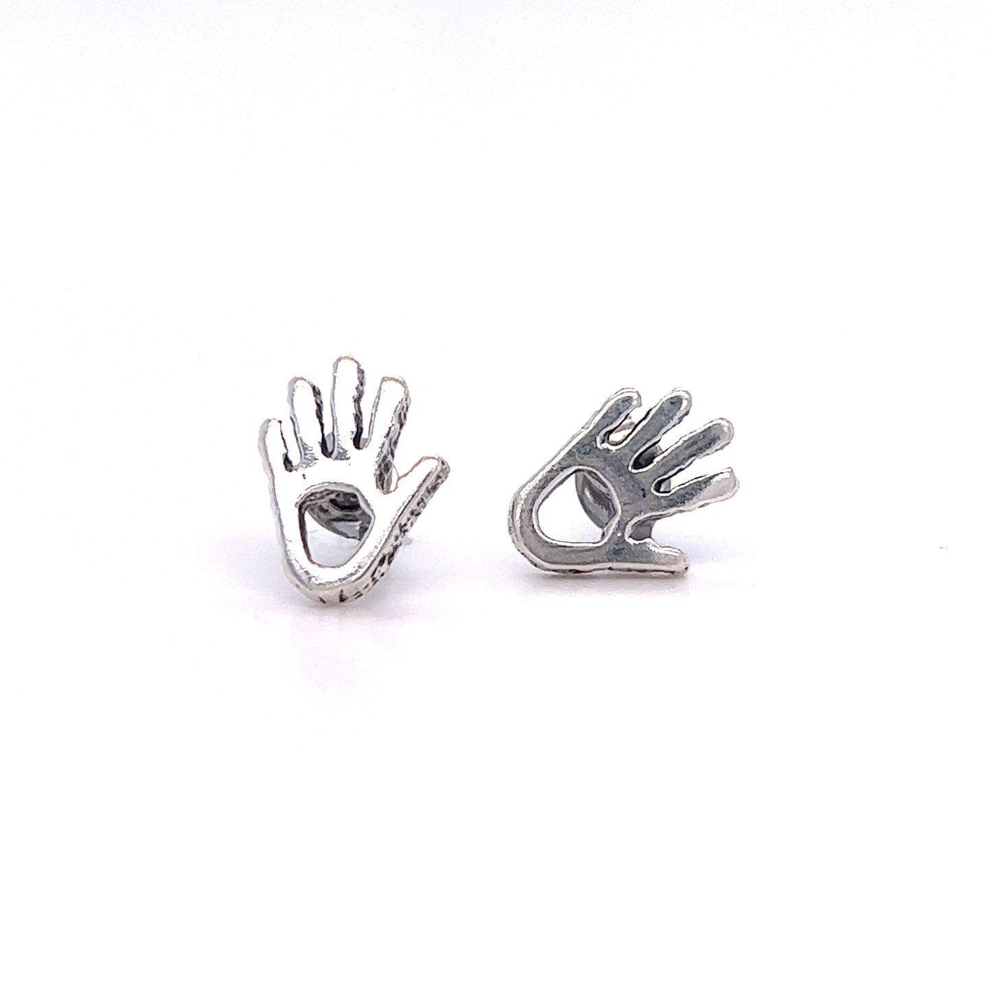 
                  
                    A pair of Super Silver Petroglyph Hand Studs, inspired by the Anasazi people and embodying the spirit of helping and healing, showcased on a white surface.
                  
                