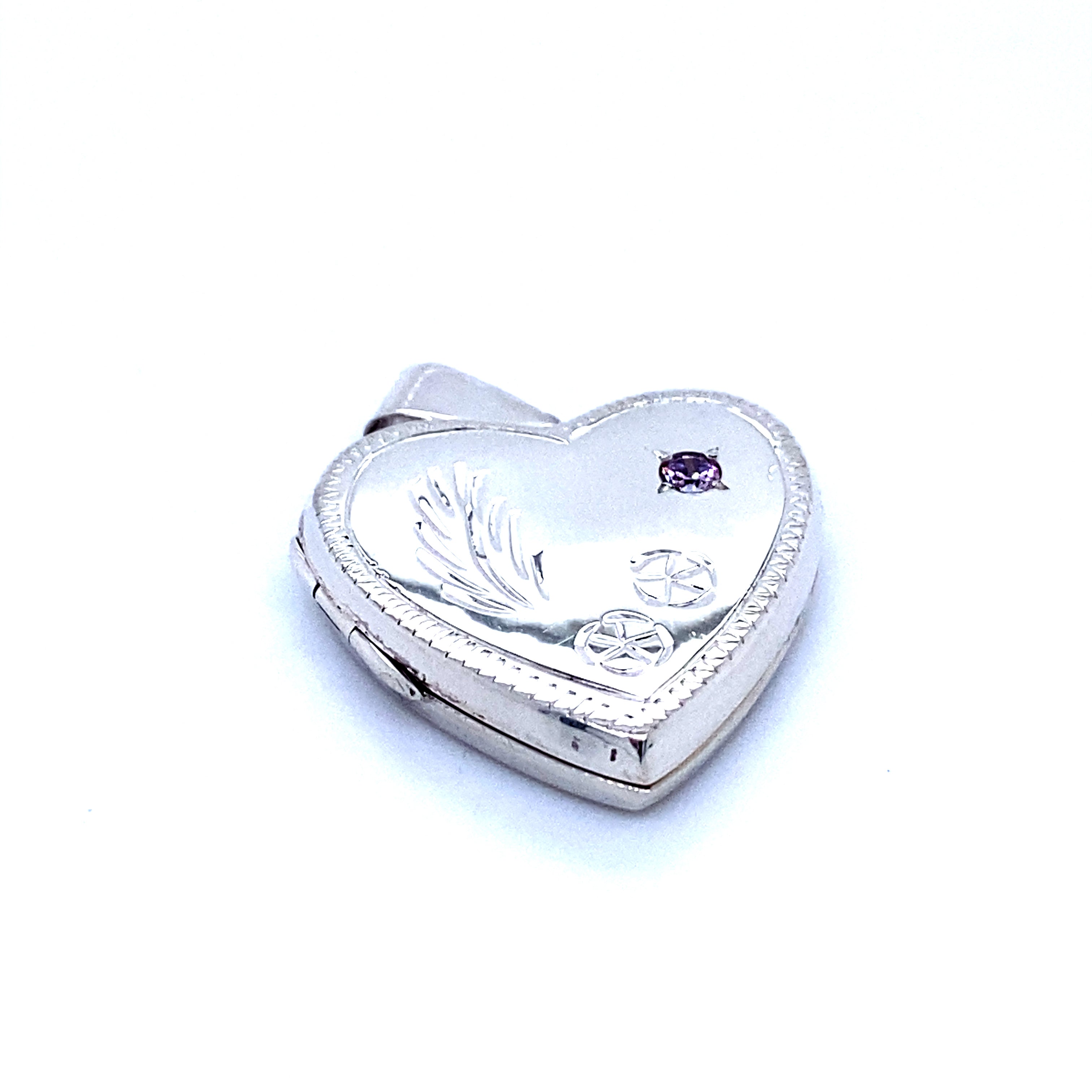 A Super Silver Heart Shaped Locket with Stone and lacy Etching with romantic charm and purple stones.