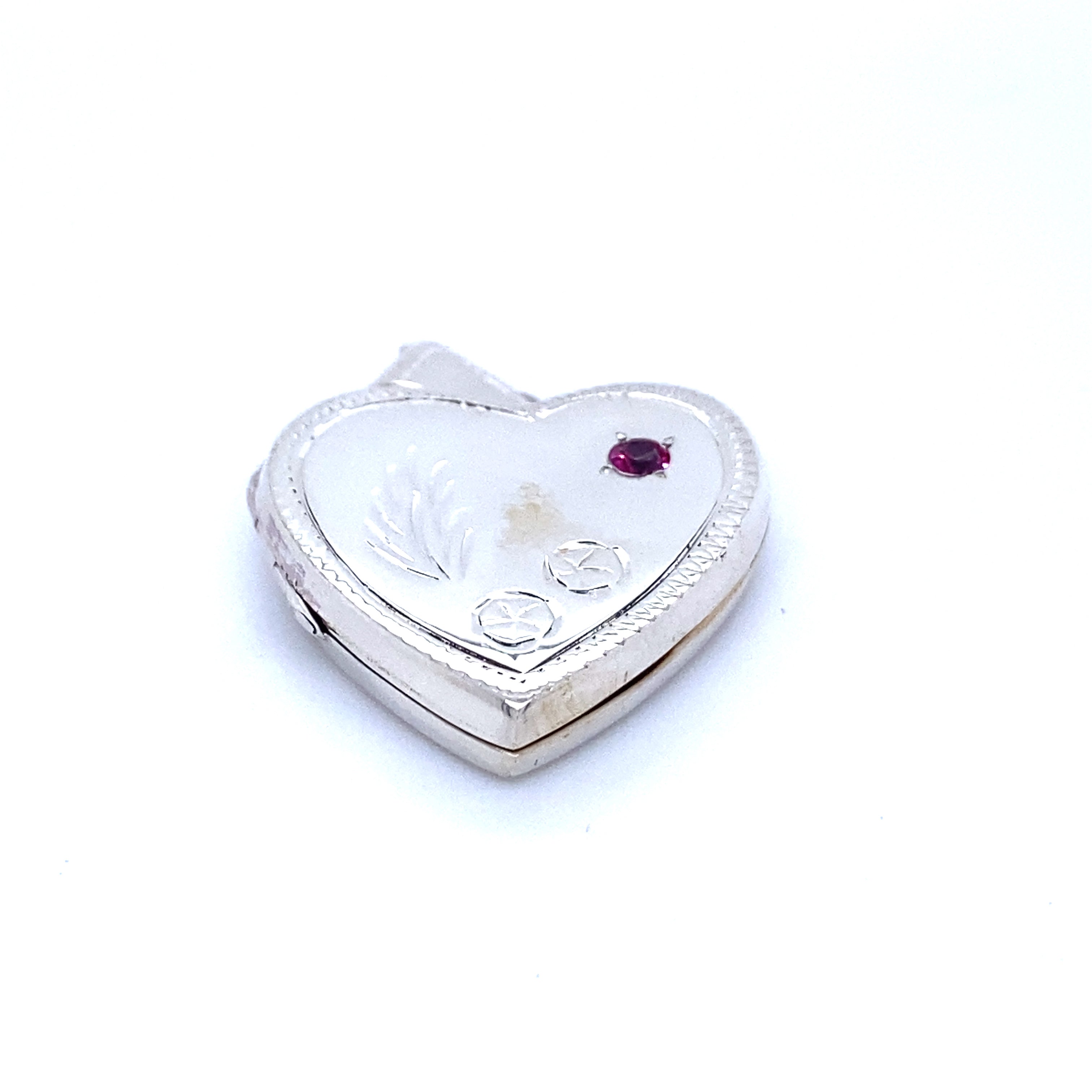 A Super Silver heart-shaped locket with a ruby stone, exuding a romantic charm.
