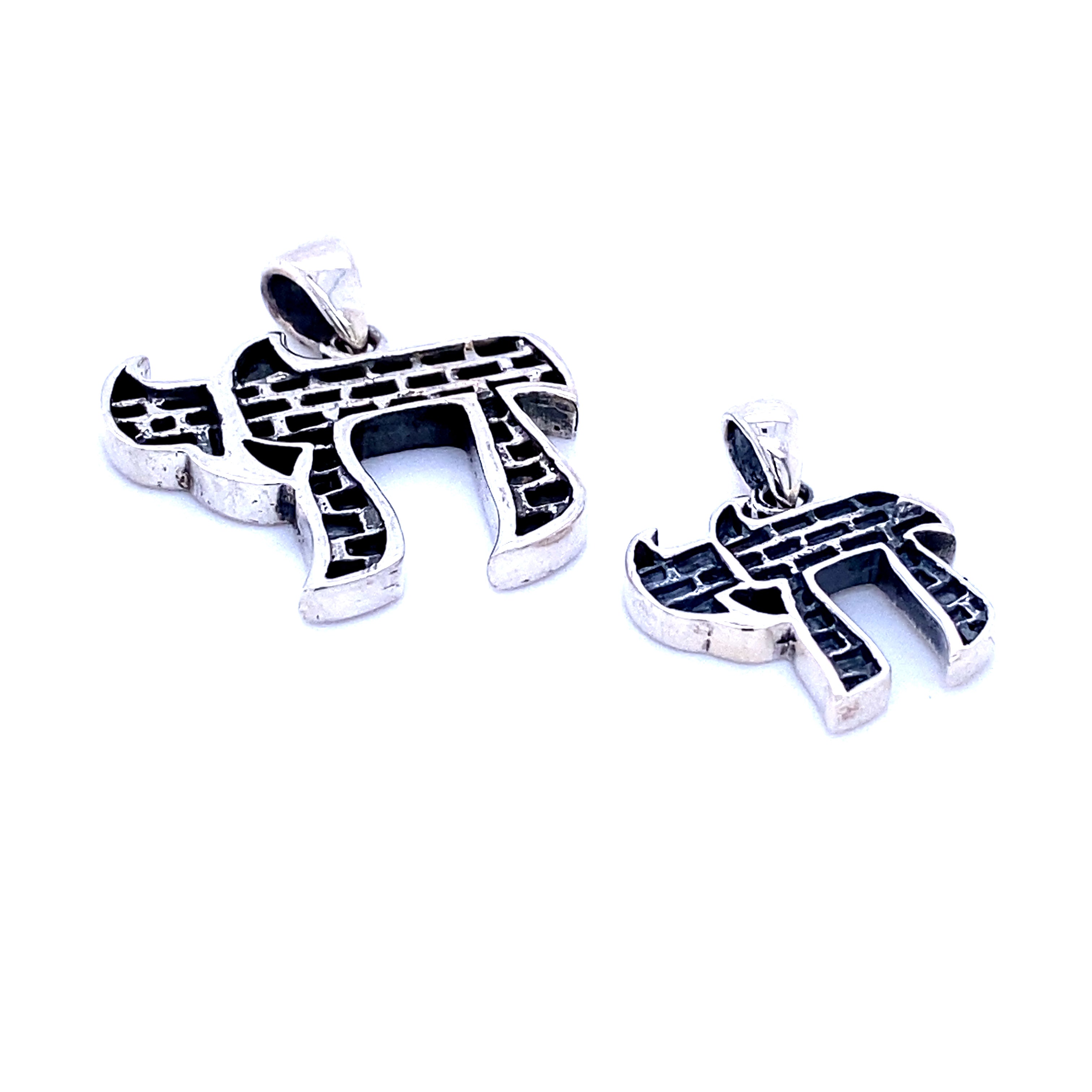 A pair of Super Silver Chai Symbol Pendants with Brick Pattern, celebrating life, set against a white background.