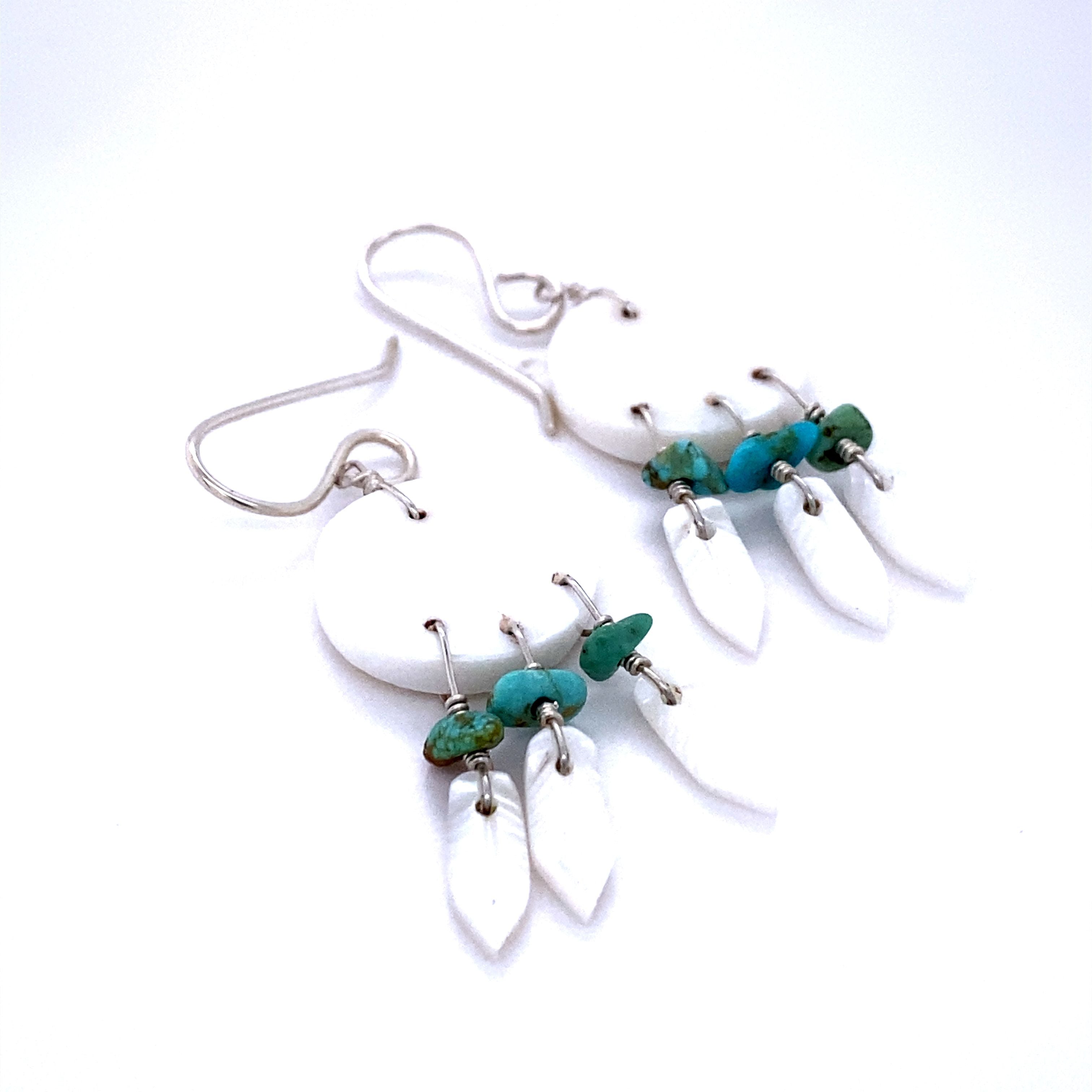 A pair of Handmade Earrings with 3 Small Stone Feathers inspired by Native American culture, handcrafted by artisans, adorned with turquoise and white beads. (Super Silver)