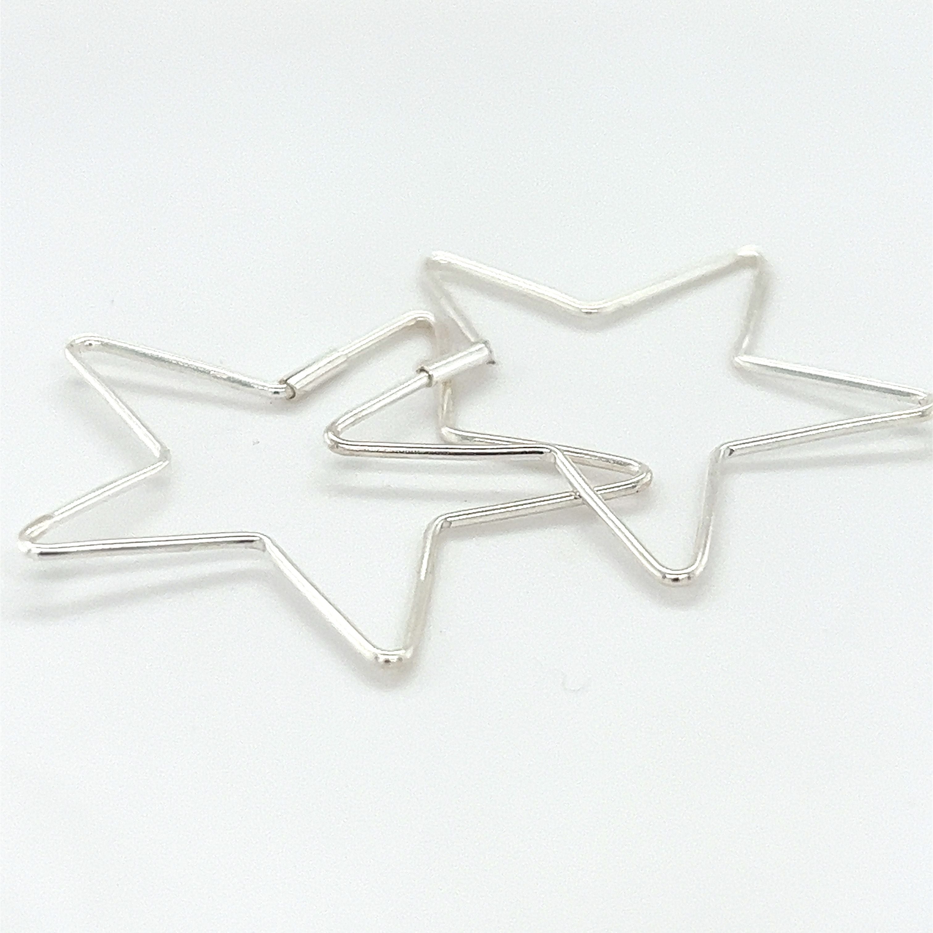 Two Delicate Star Shaped Hoops by Super Silver on a white surface.