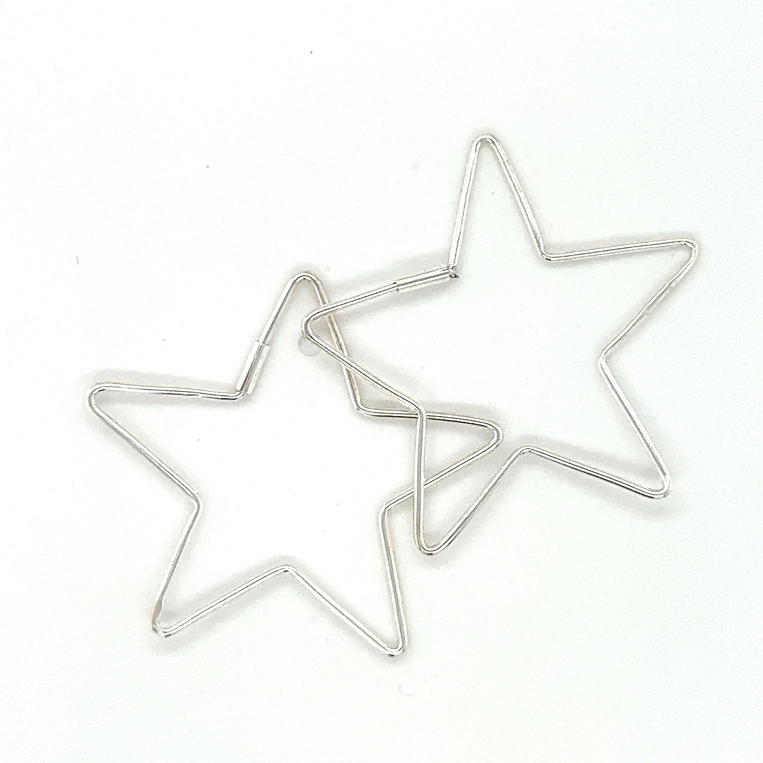 Two Delicate Star Shaped Hoops earrings by Super Silver on a white surface.