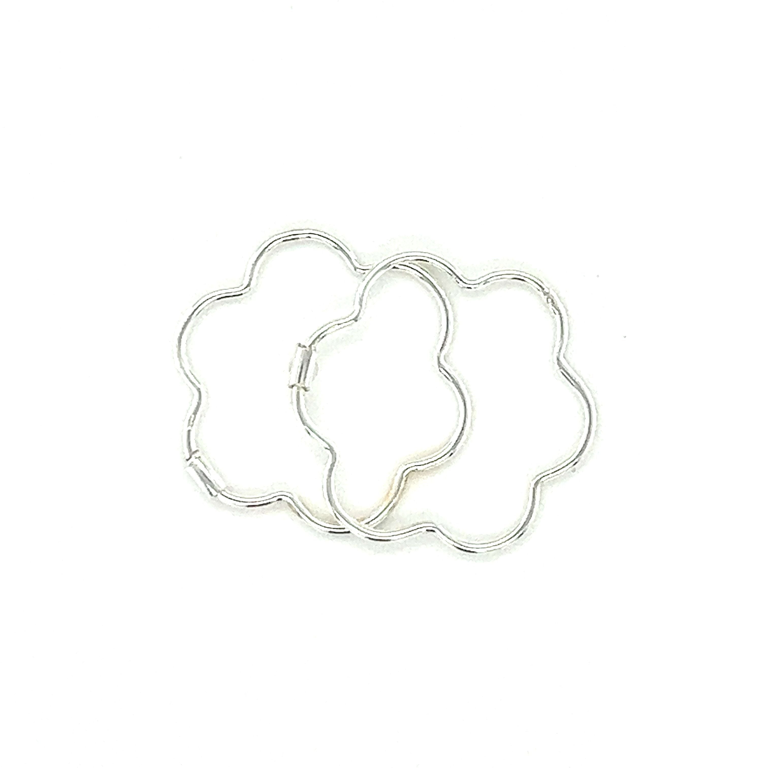 A minimalist Super Silver Delicate Flower Shaped Hoops on a white surface.