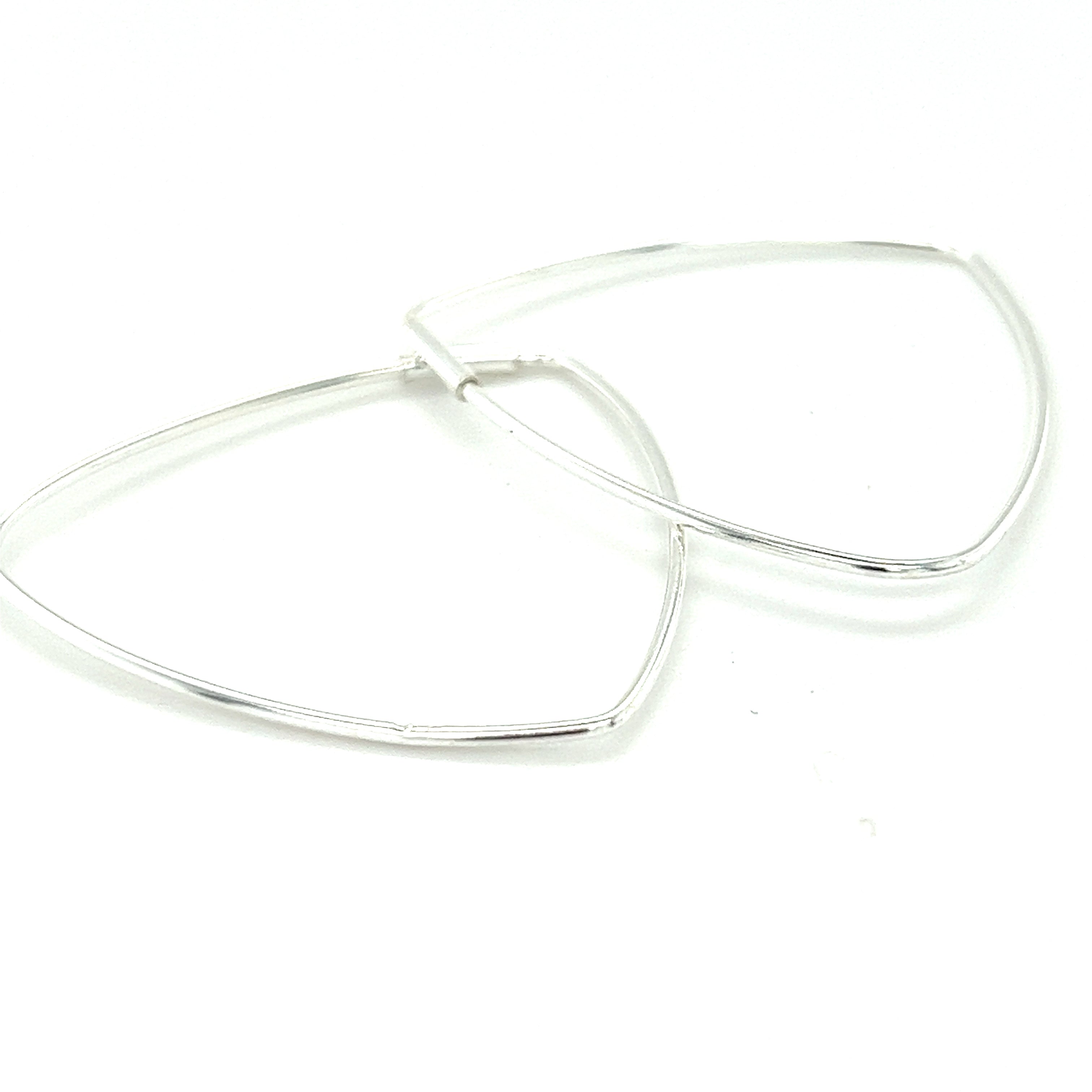 A pair of Super Silver Delicate Triangle Shaped Hoops on a white surface.