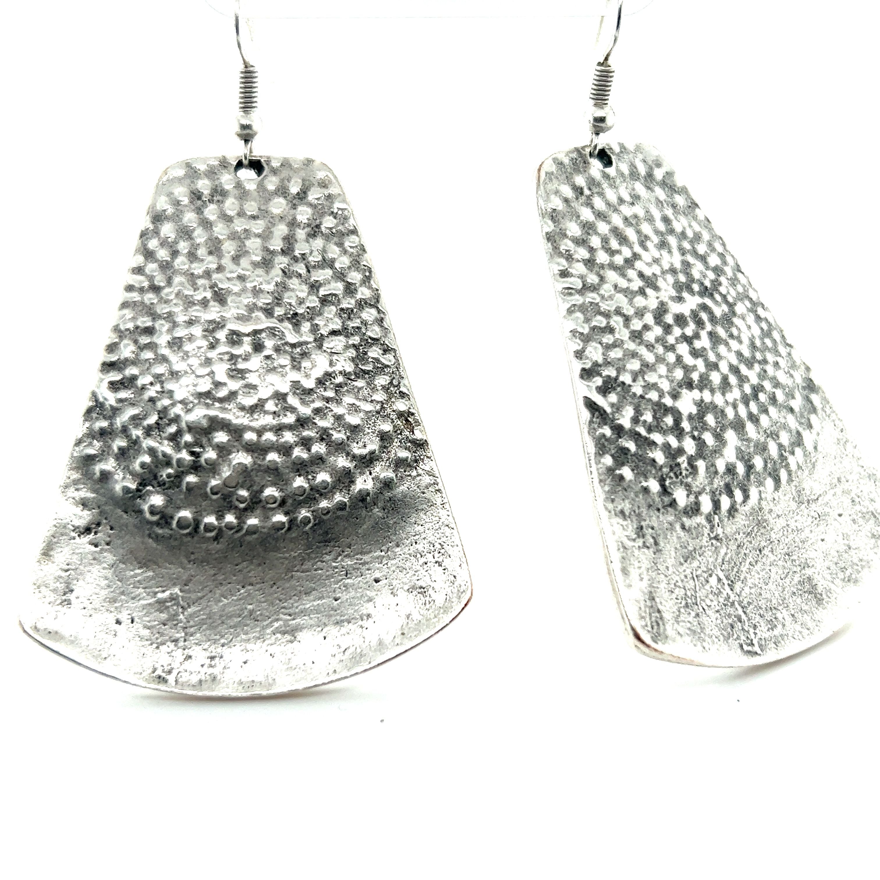 A pair of Super Silver Long Boho Statement Earrings with dots on them.