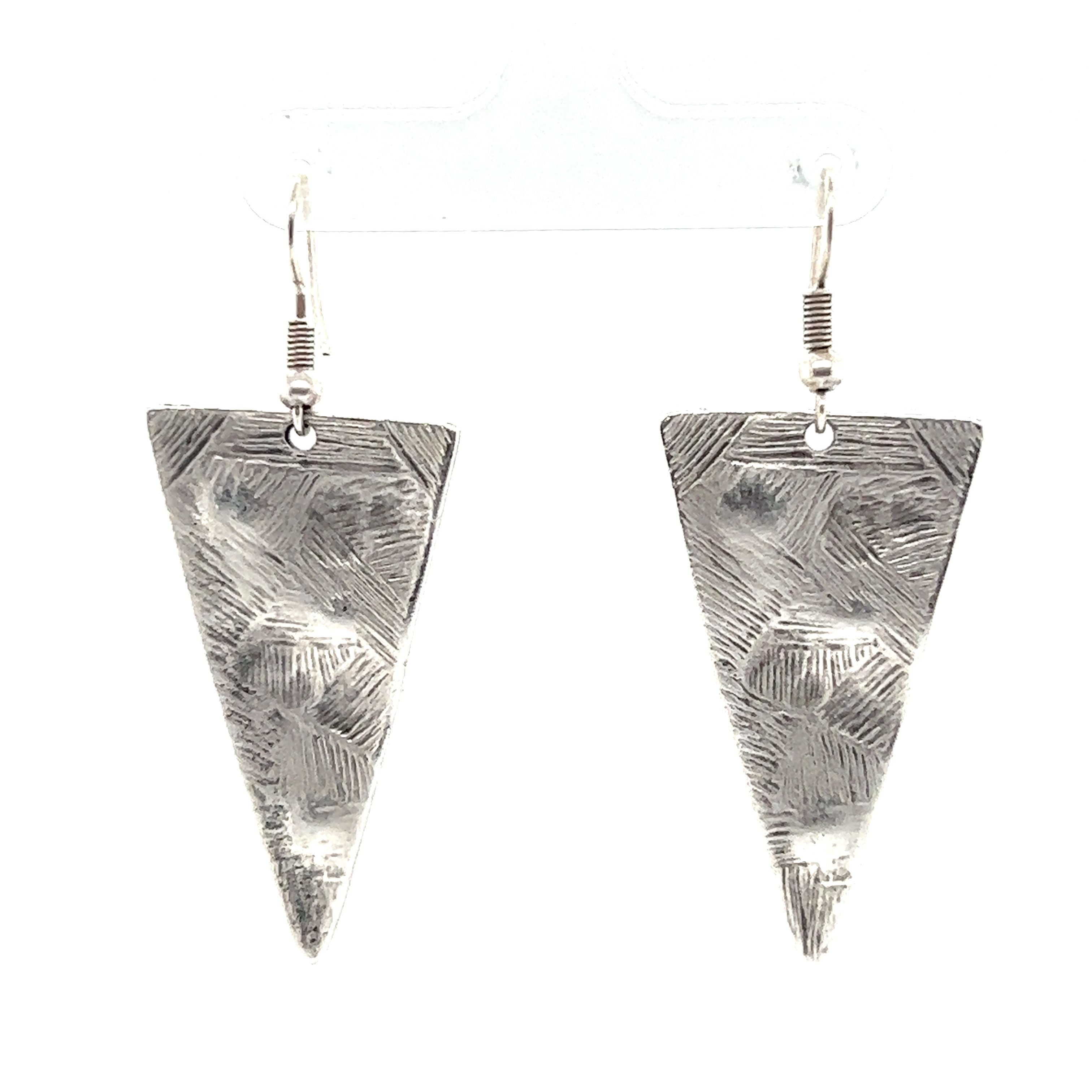 A pair of silver Super Silver triangular boho statement earrings, perfect for urban boho jewelry lovers. These boho-chic earrings stand out beautifully against a white background.