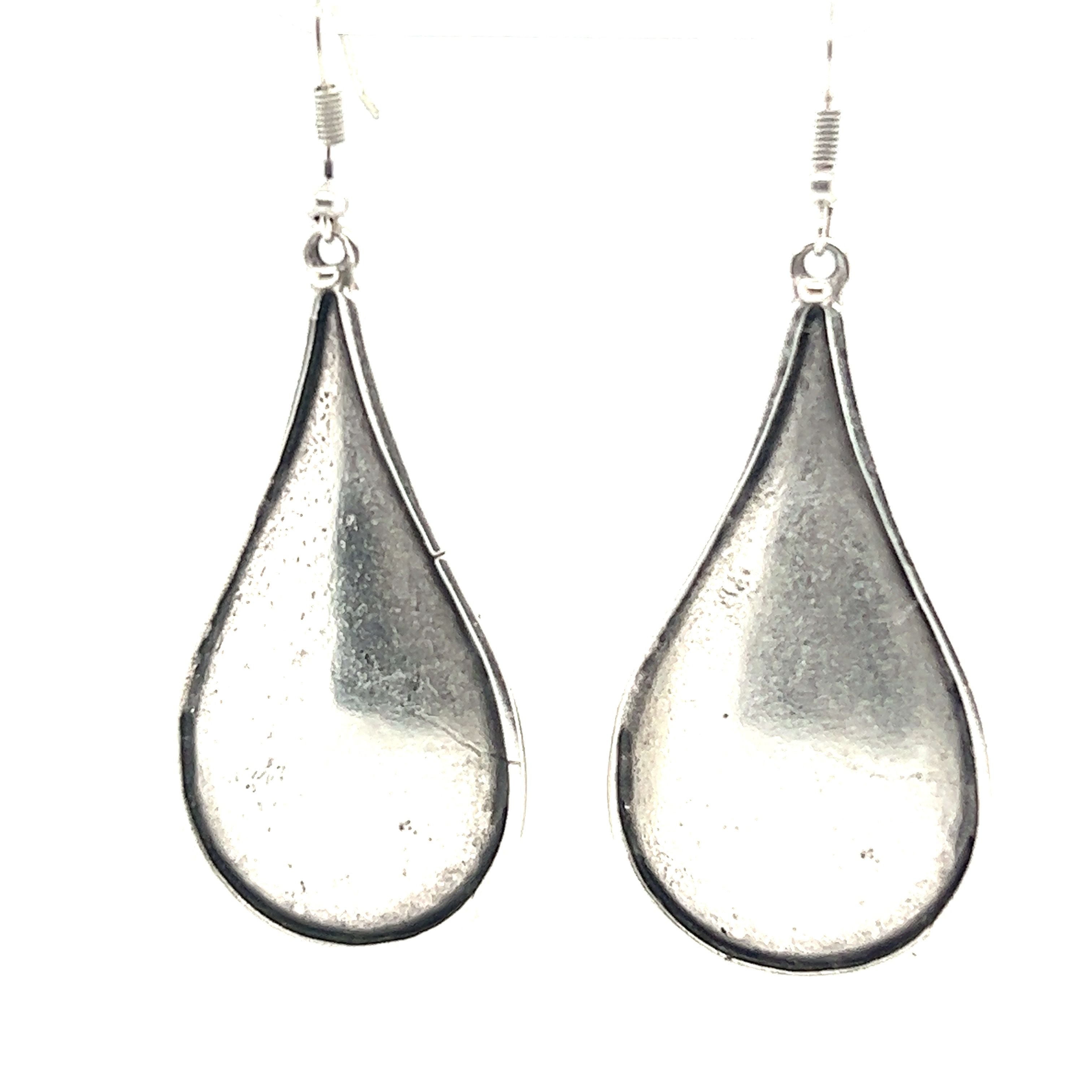 A pair of Super Silver Long Boho Statement Earrings on a white background.
