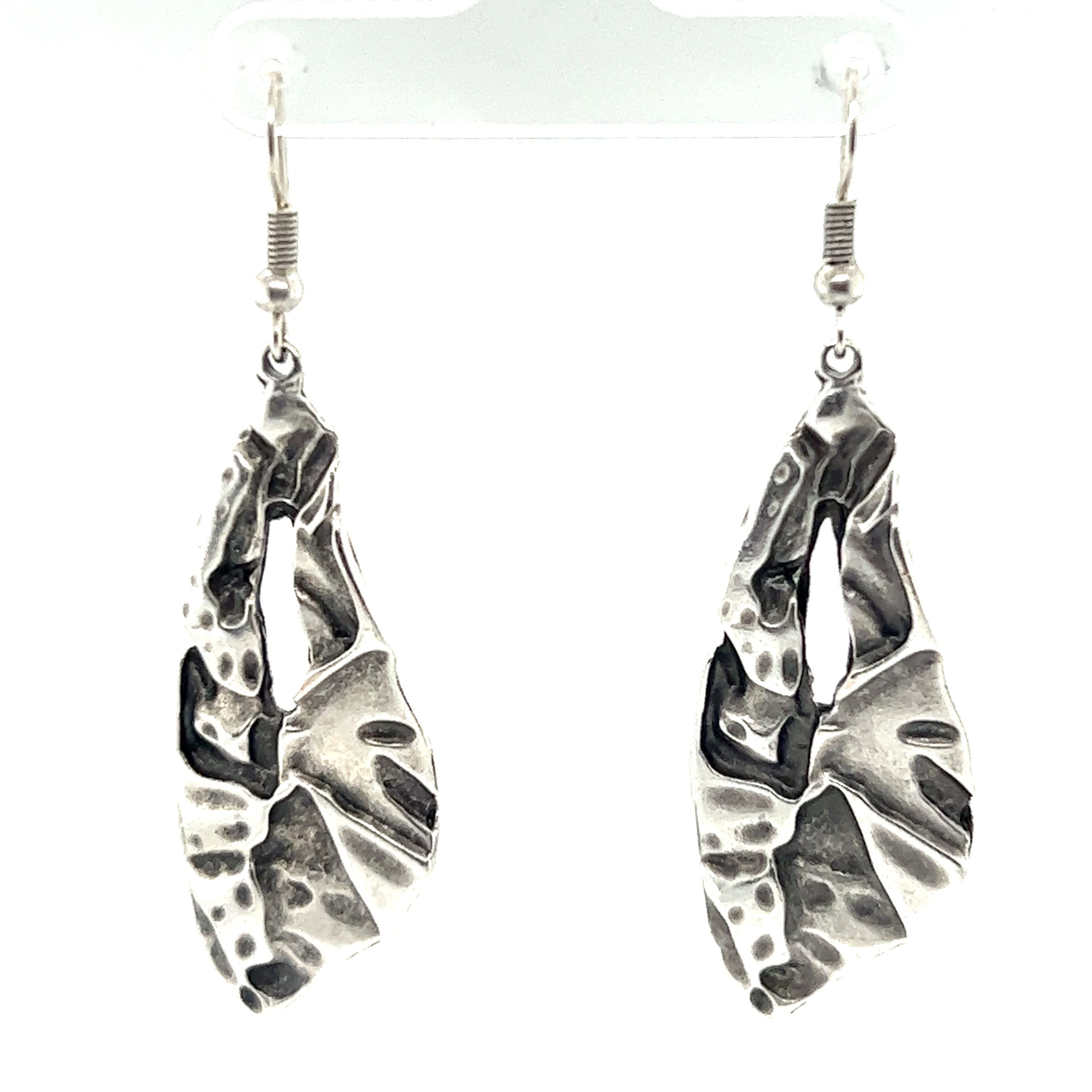 A pair of trendy and boho-chic Triangular Boho Statement Earrings adorned with leaves, making them the perfect urban boho jewelry accessory.