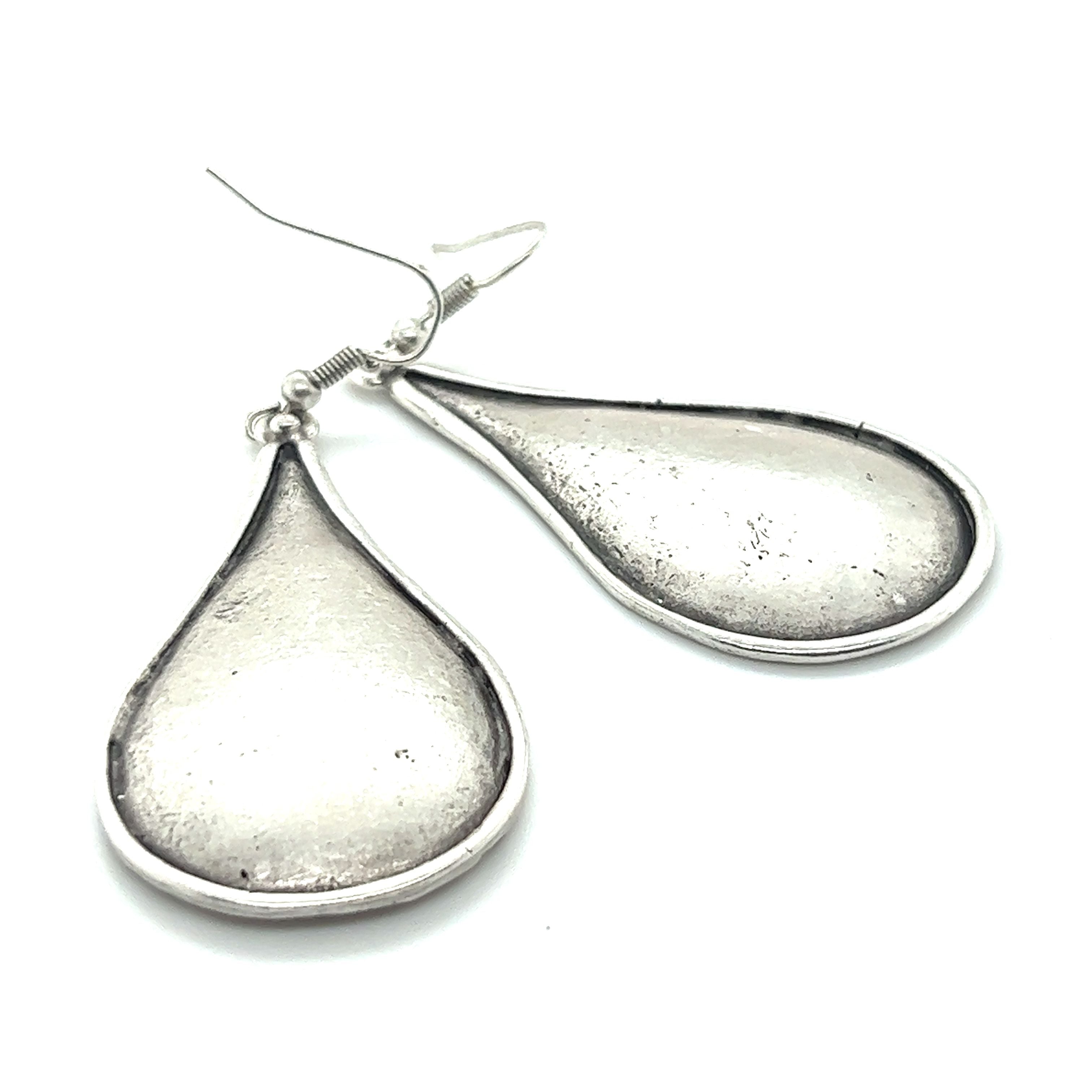 A pair of Super Silver Long Boho Statement Earrings on a white background, making for a dramatic accessory.