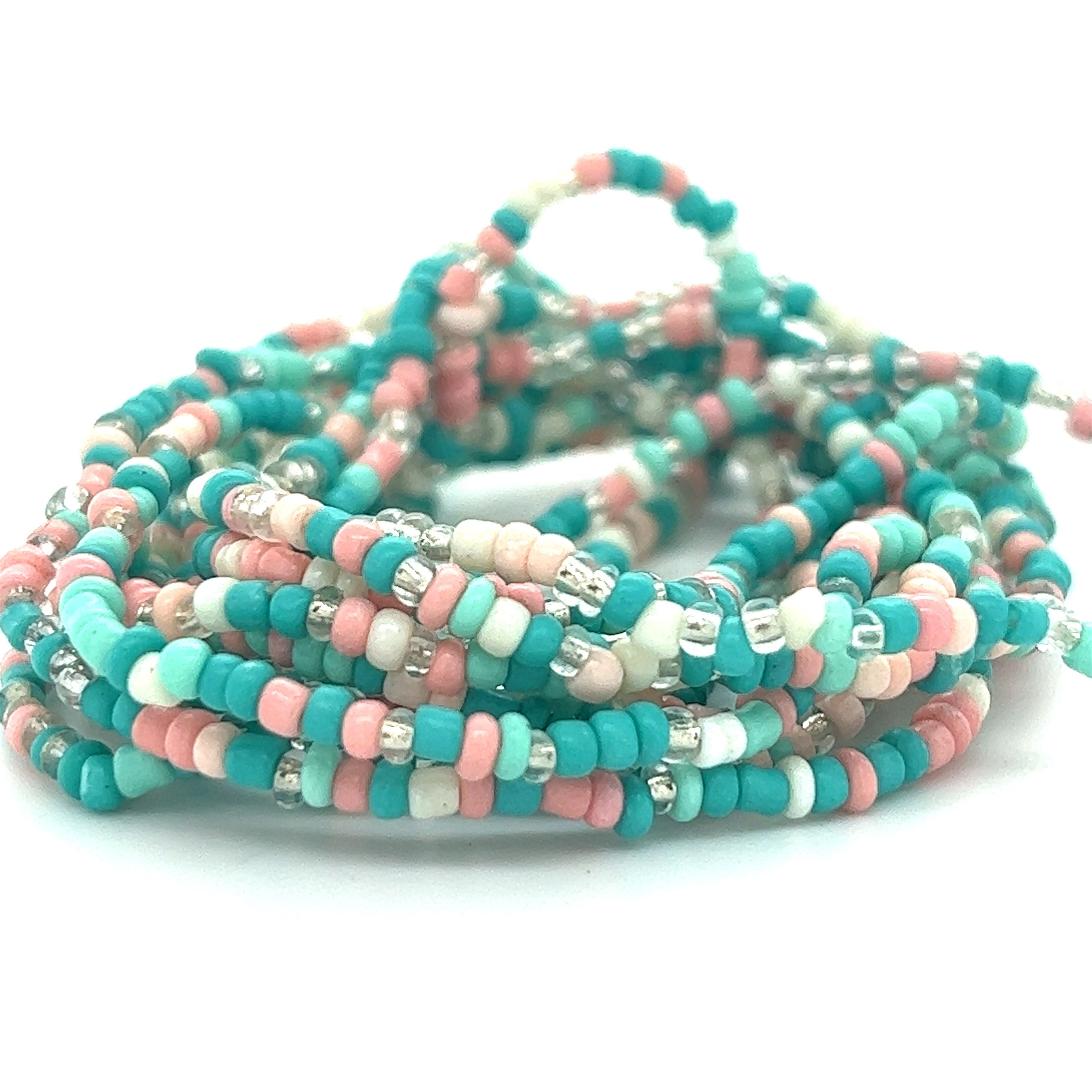 A stack of Super Silver Dainty Beaded Bracelets in vibrant colors.