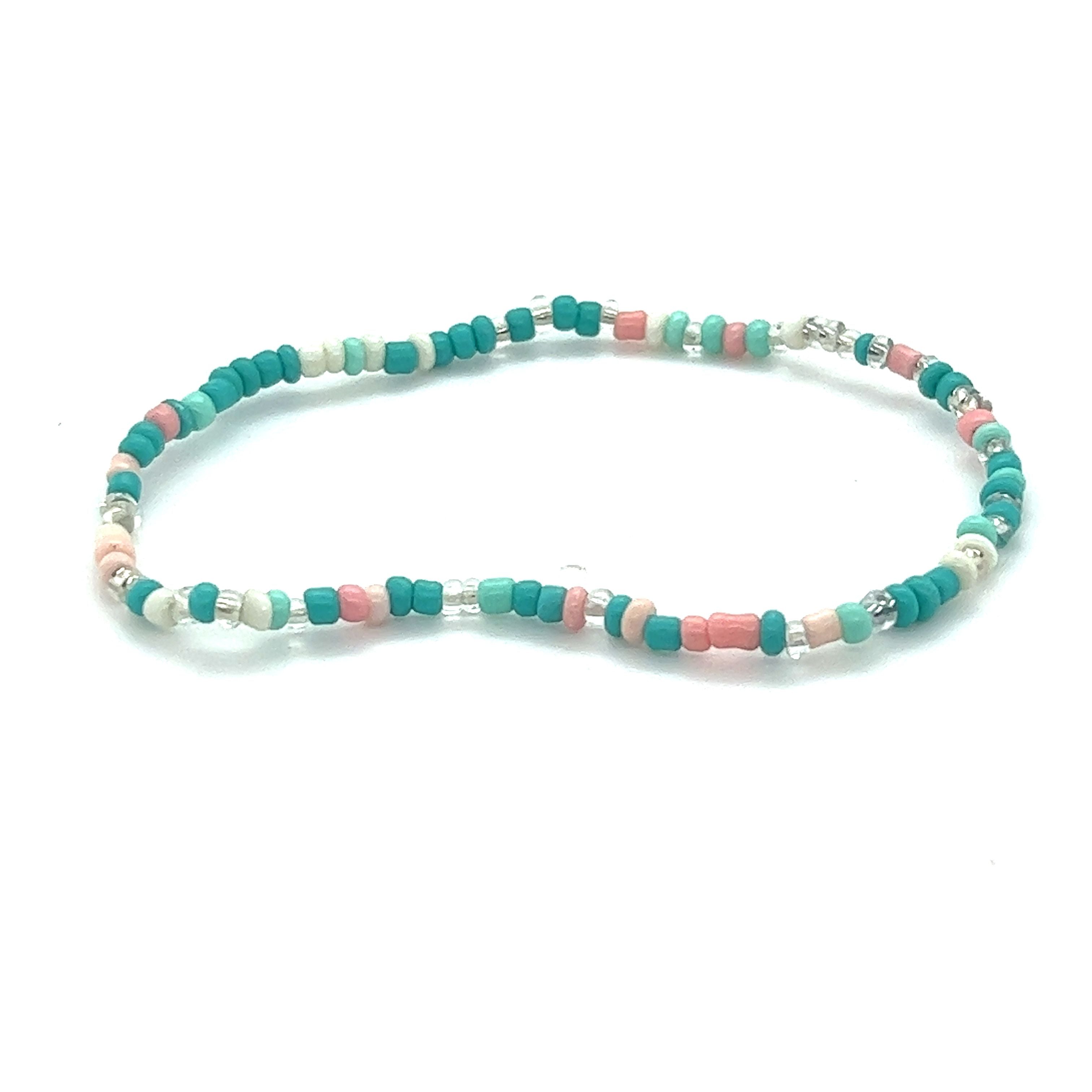 A Super Silver Dainty Beaded Bracelets featuring pops of pink on a white background.