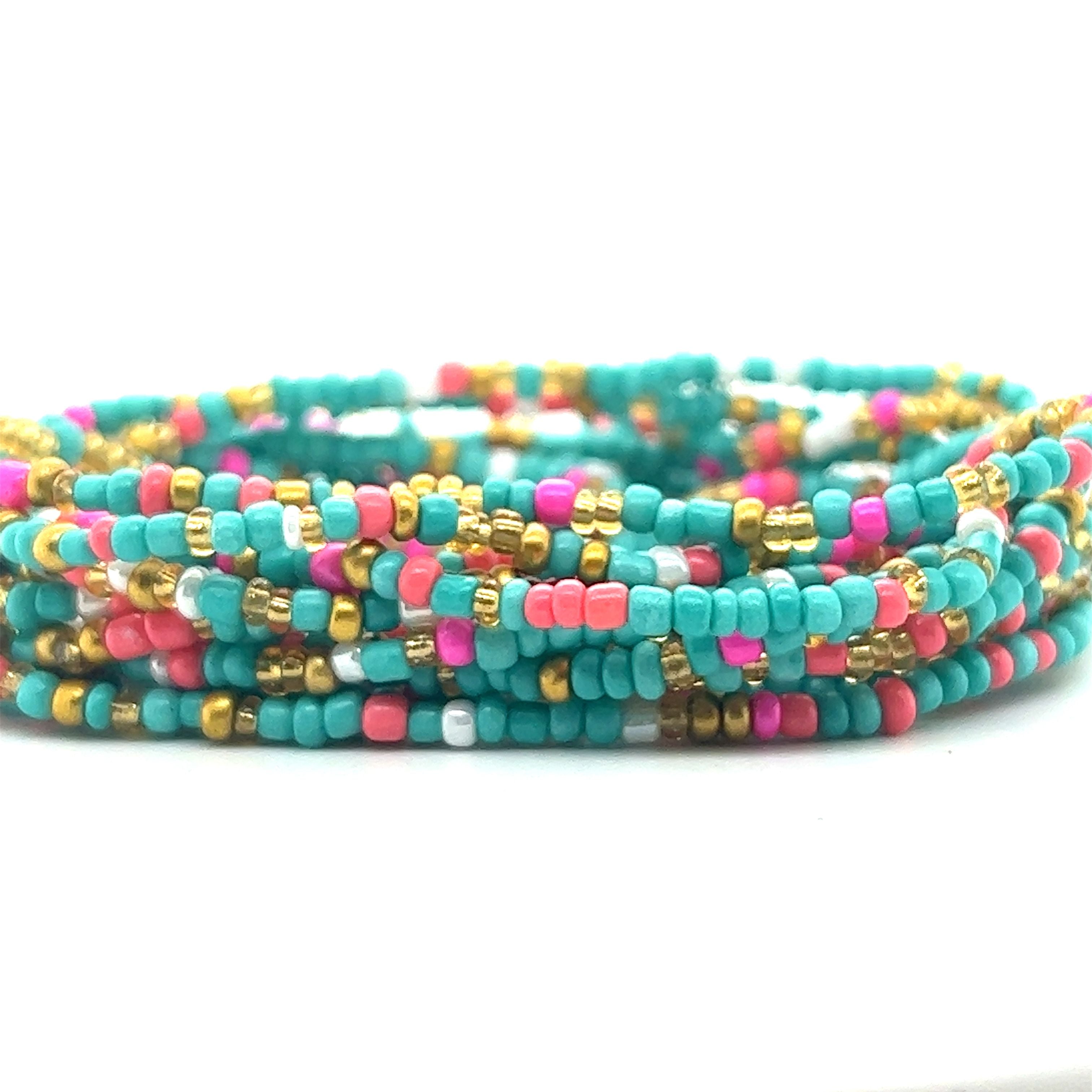 A Dainty Beaded Bracelet featuring vibrant colors of turquoise and pink, elegantly displayed on a pristine white surface by Super Silver.