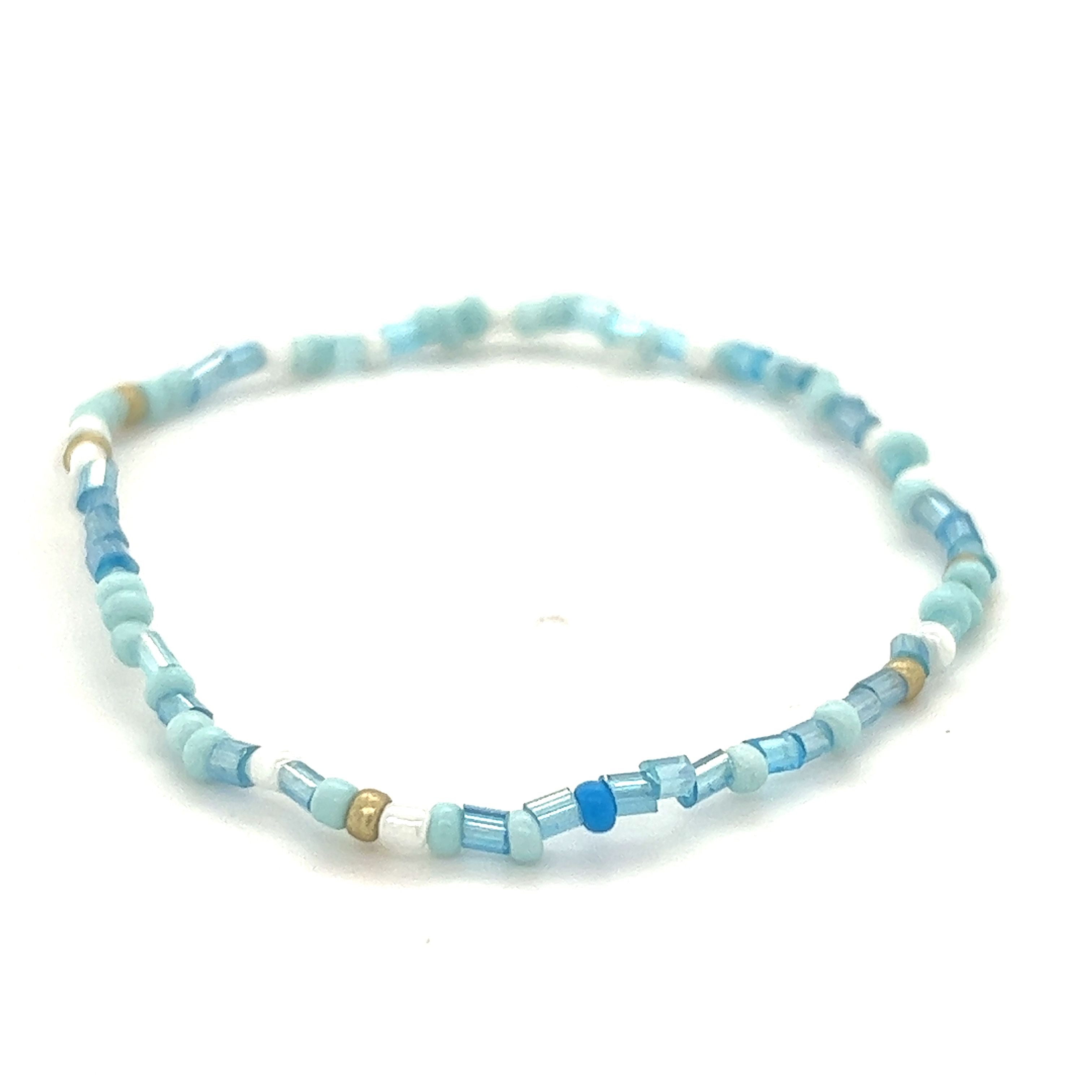A Super Silver Dainty Beaded Bracelet with blue glass beads and a gold seed bead.