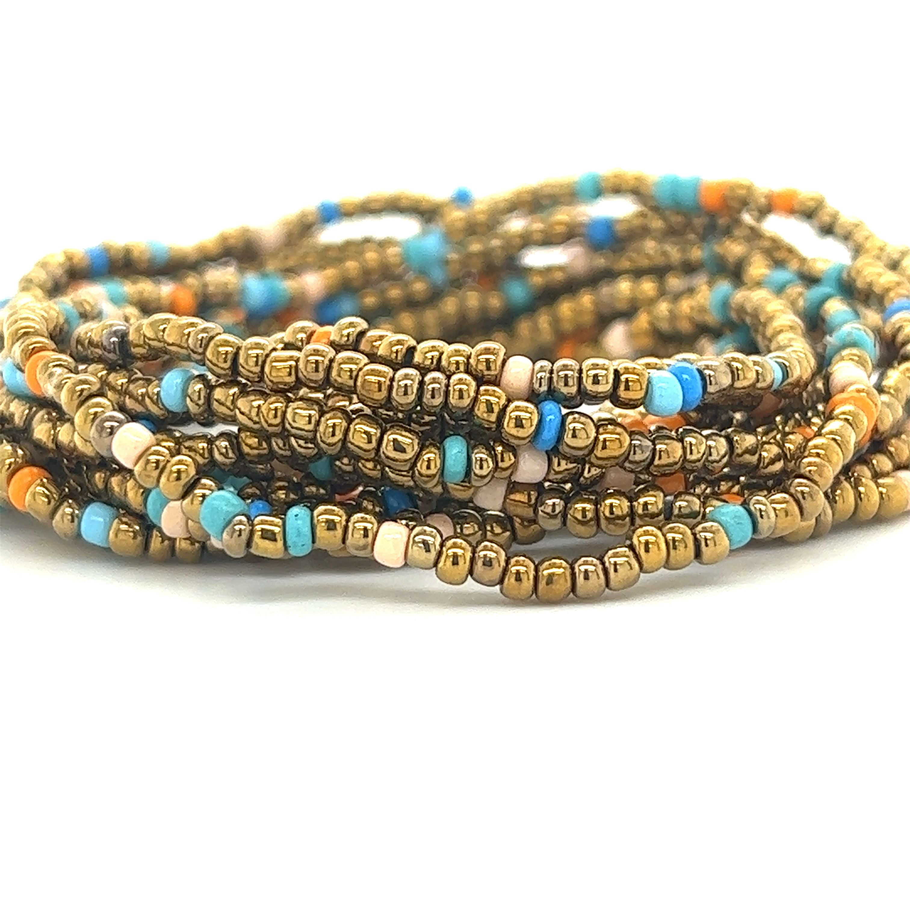 A stack of Super Silver Dainty Beaded Bracelets in vibrant gold and blue colors.