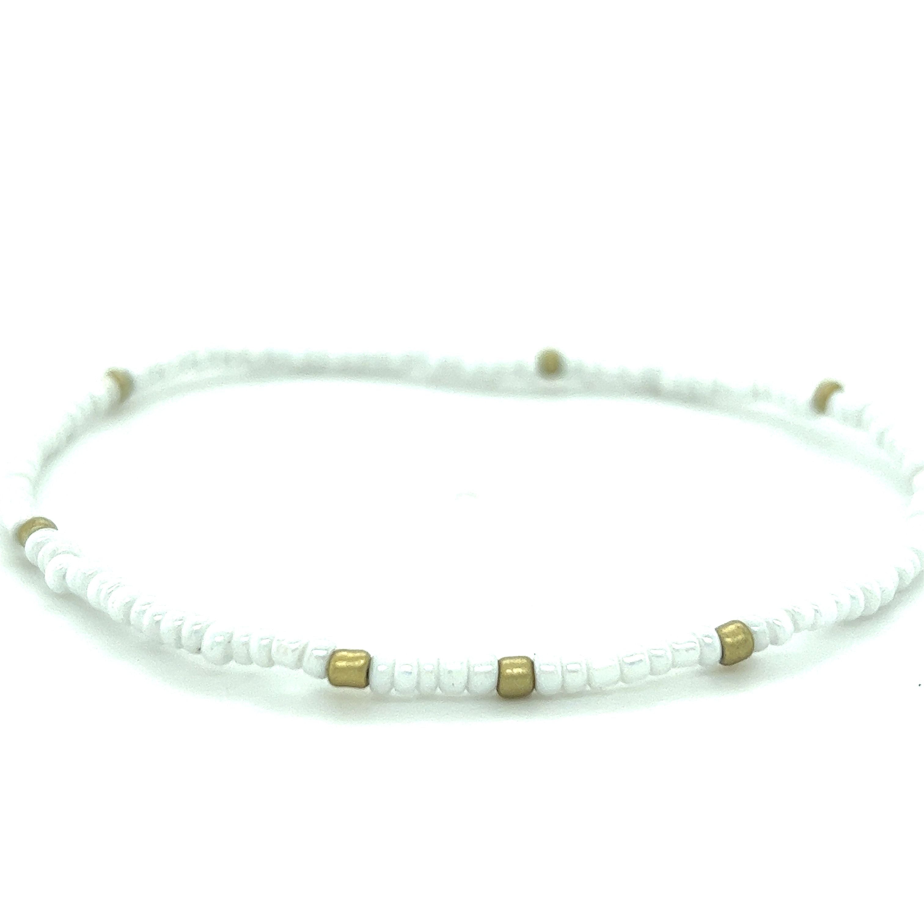 A Super Silver Dainty Beaded Bracelet with gold accents on a white background.