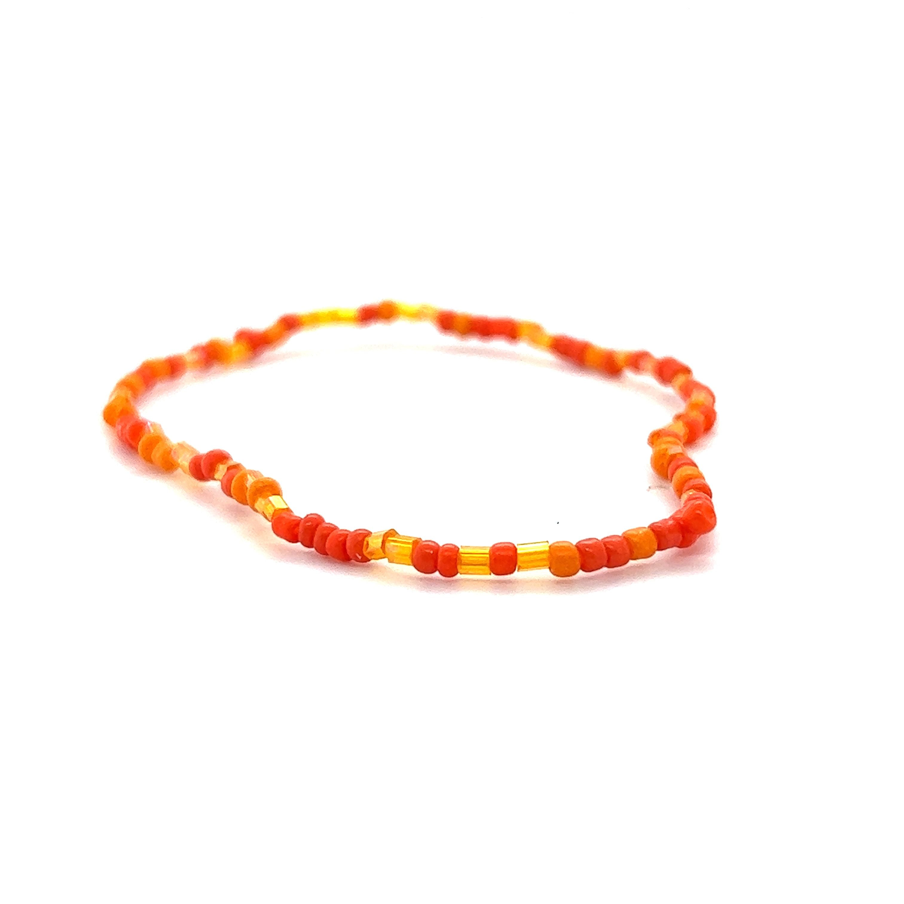 A vibrant Dainty Beaded Bracelets adorned with orange and yellow beads, displayed against a crisp white background.