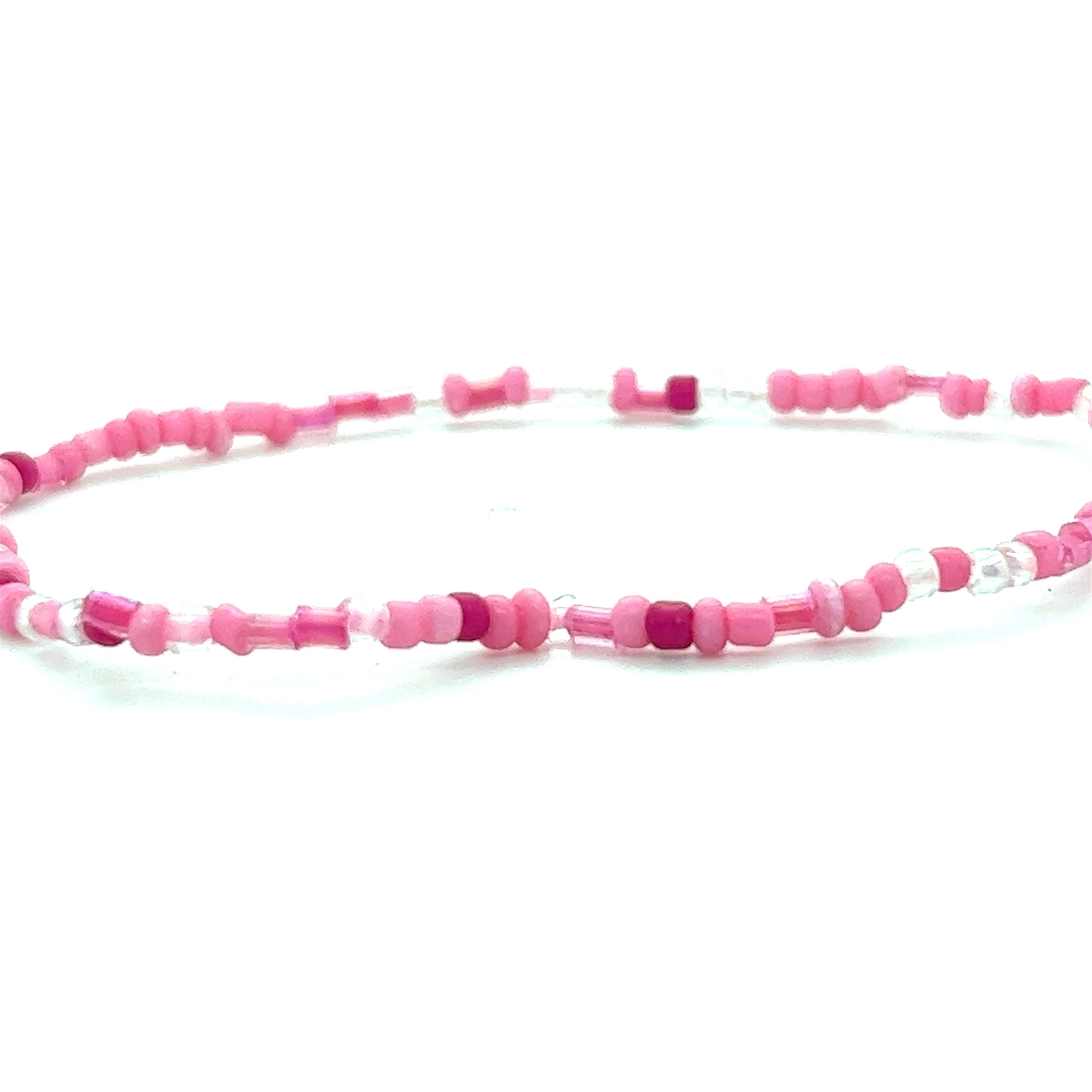 A Dainty Beaded Bracelet by Super Silver featuring pink and white colors on a white background.