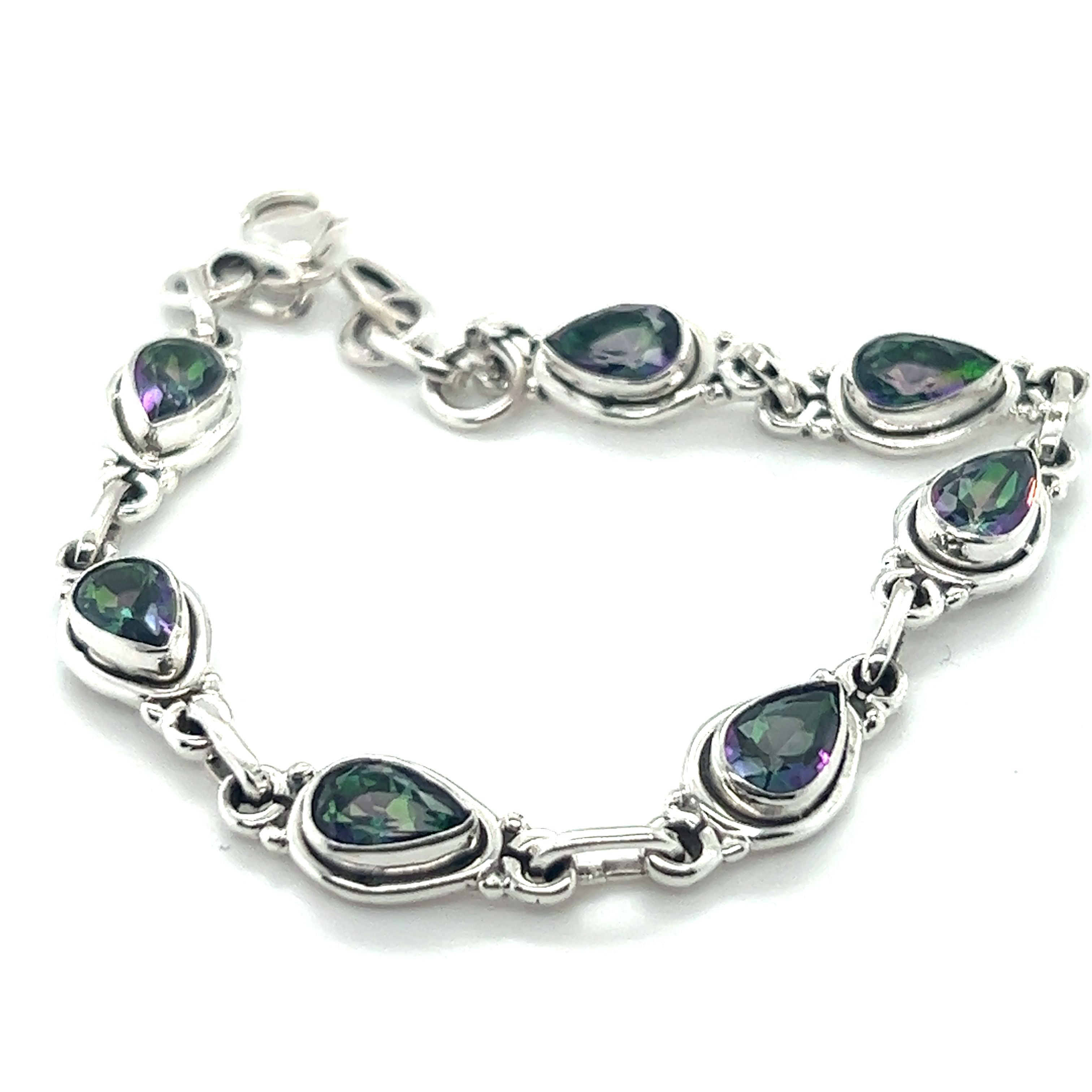A sterling silver bracelet featuring multiple teardrop-shaped green gemstones set in individual links, this stunning piece is reminiscent of a classic Rainbow Topaz Bordered Teardrop Bracelet.