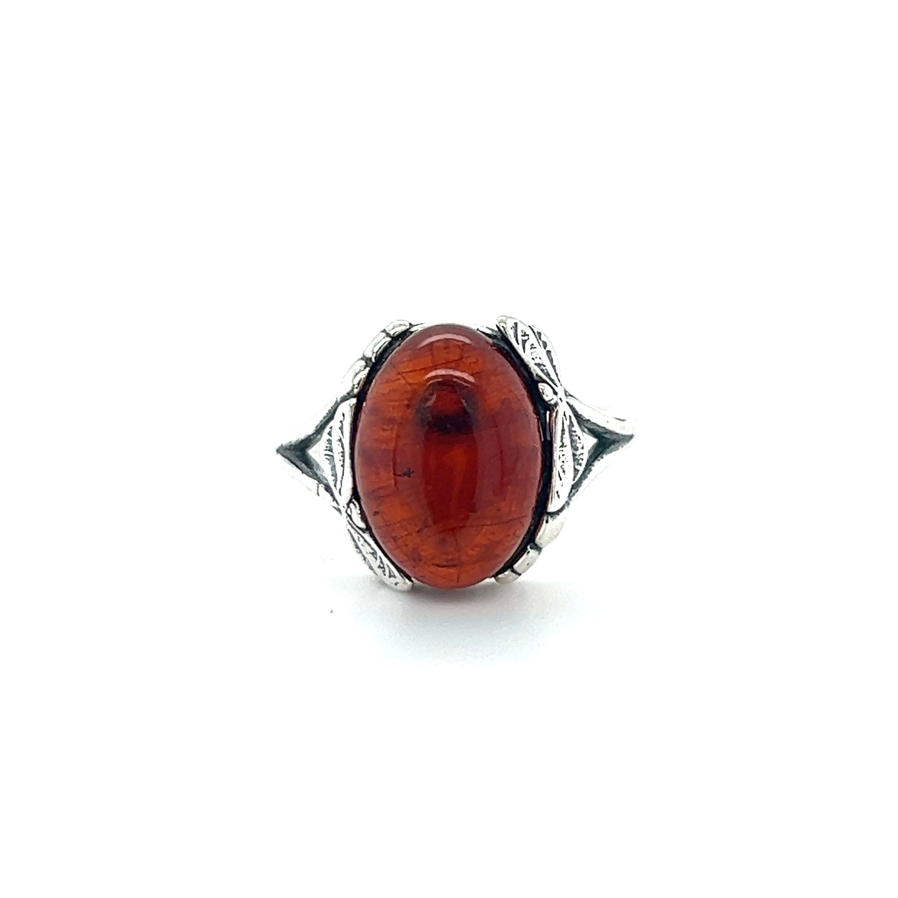 A Dragonfly Band Amber Ring by Super Silver with a large amber stone in the center.