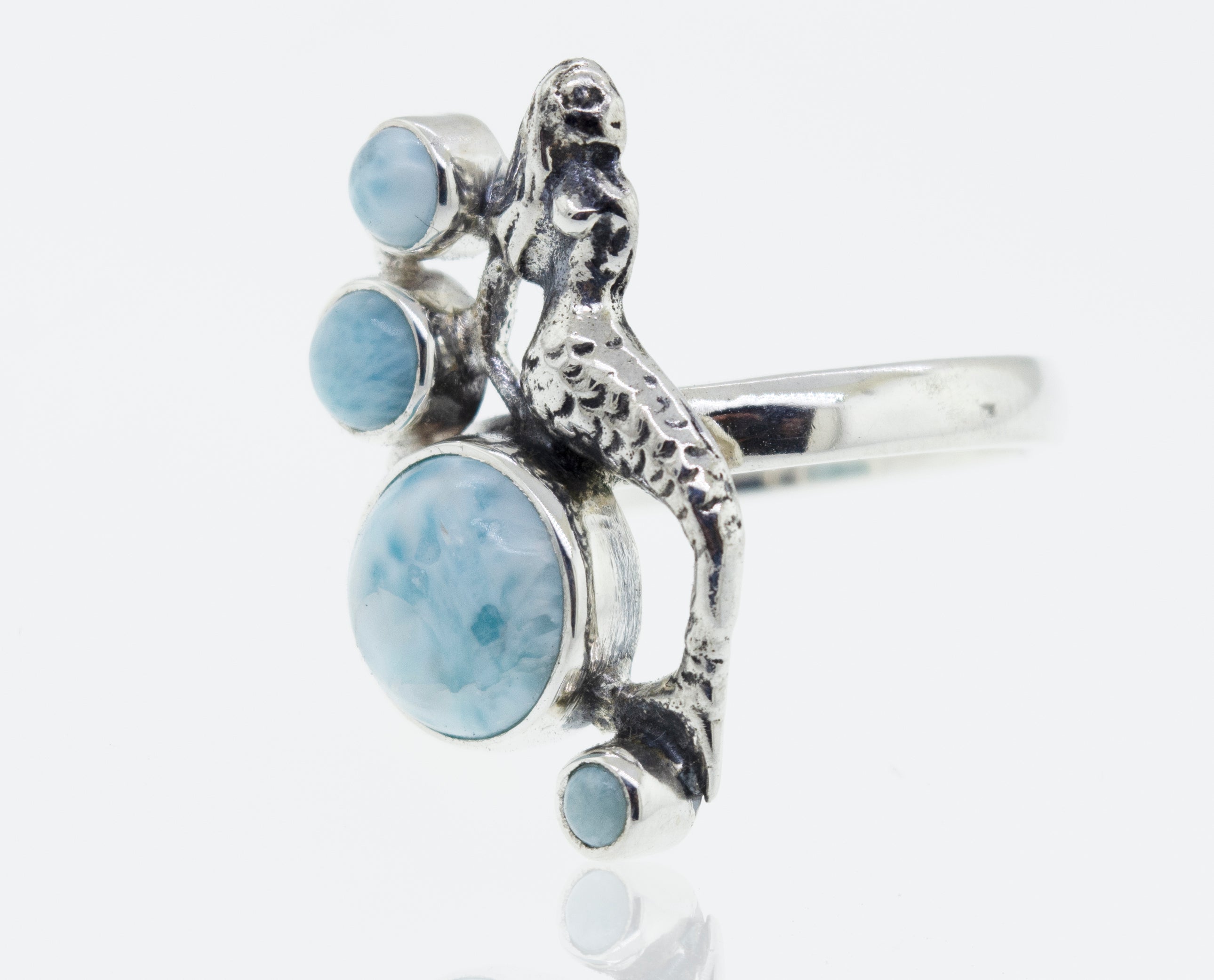 A mythical sterling silver mermaid ring adorned with aquamarine stones.
Product Name: Mermaid Ring with Larimar
Revised Sentence: A mythical sterling silver mermaid ring adorned with larimar stones.