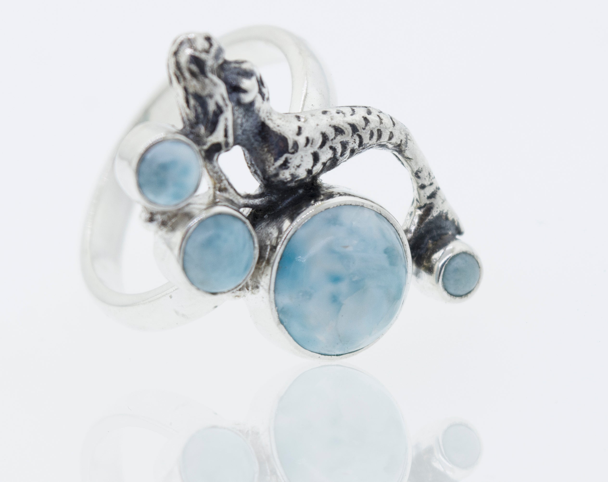 A Mermaid Ring with Larimar featuring a mythical mermaid carved on a larimar stone.