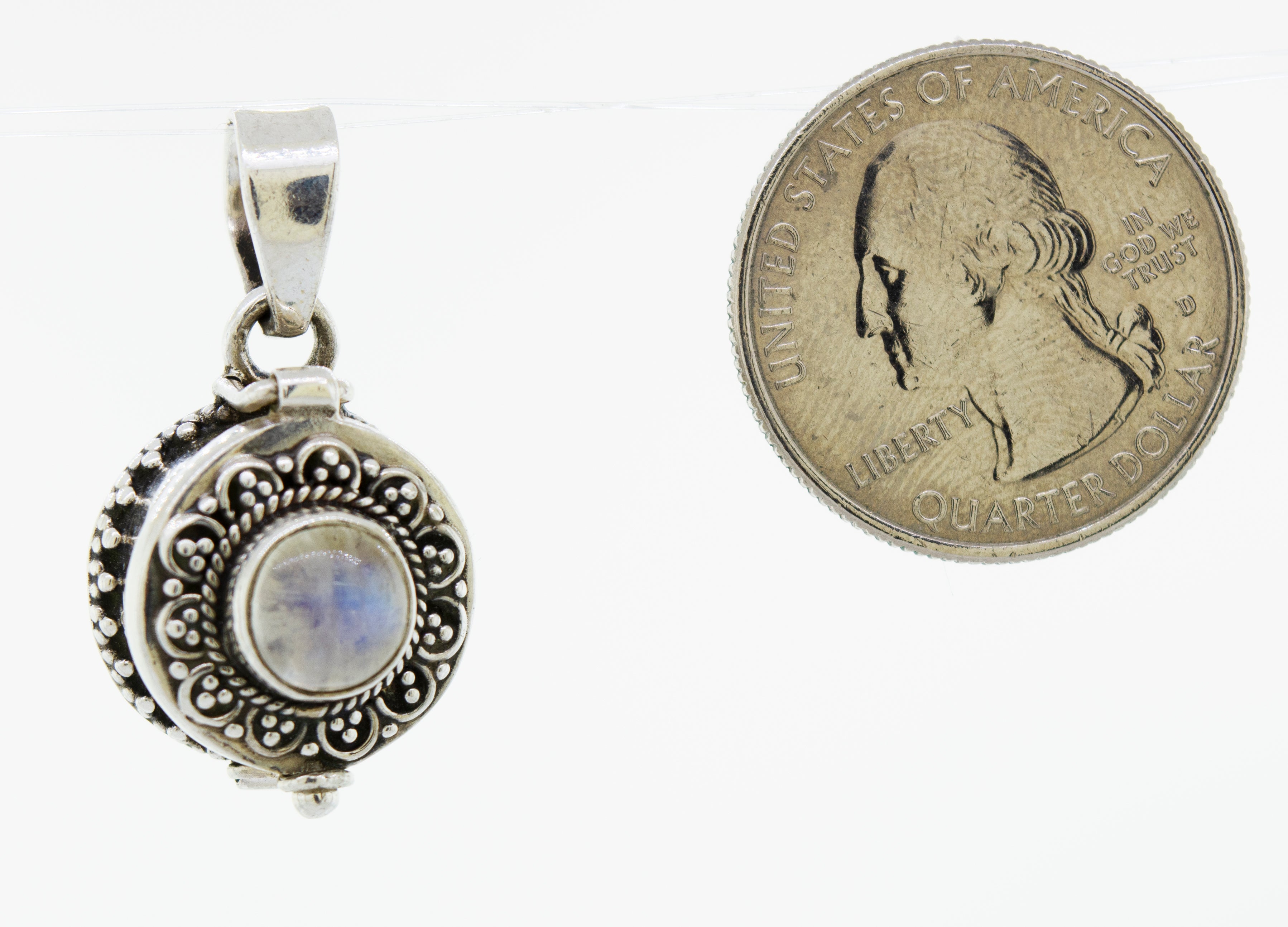 A Super Silver Stone Poison Locket pendant with a turquoise stone next to it.