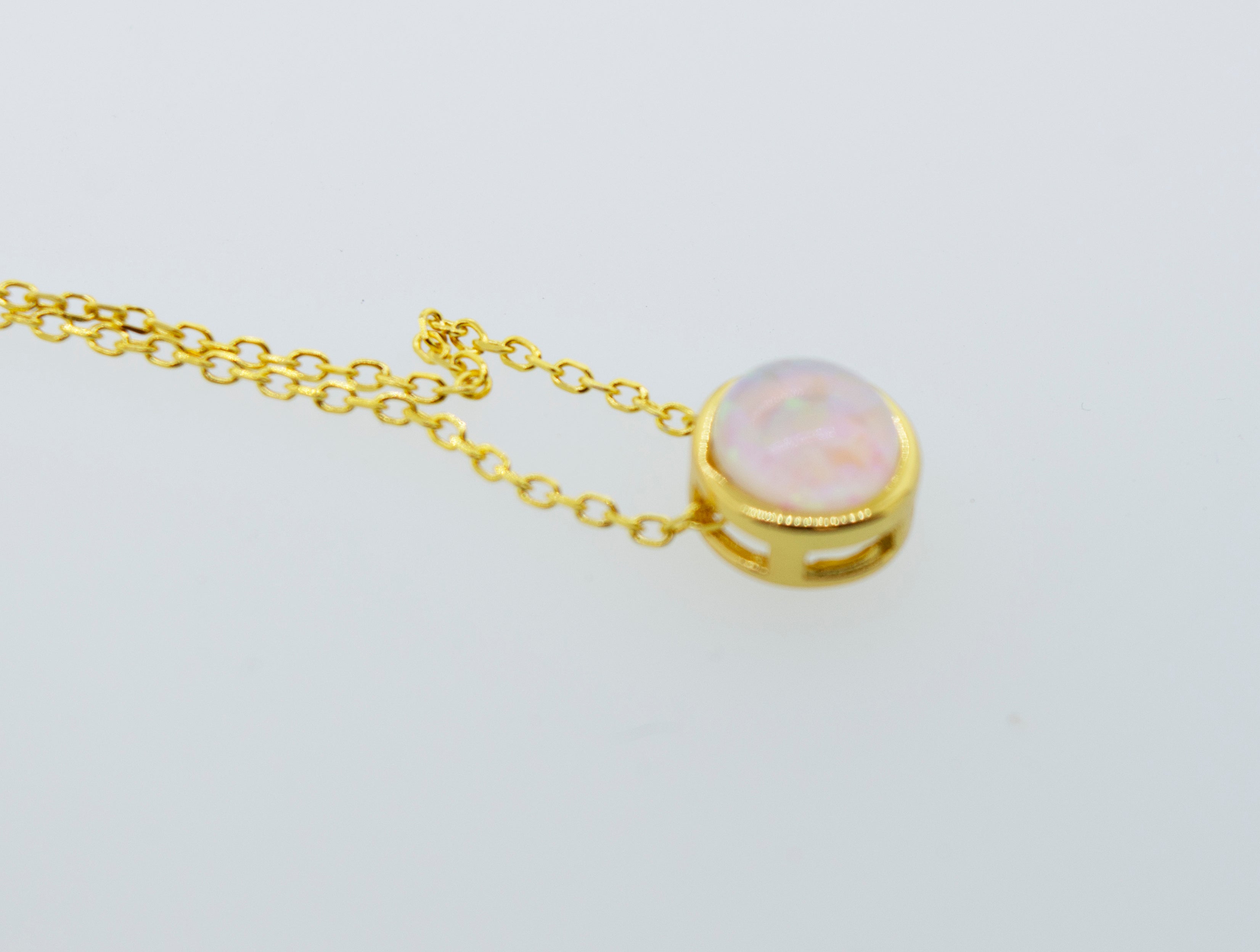 A Super Silver Australian opal necklace on a gold chain.
