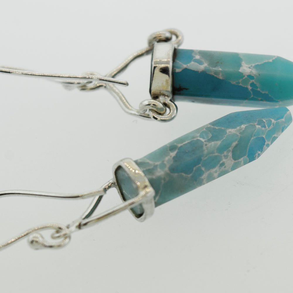 A pair of Super Silver Obelisk Shape Raw Larimar Earrings with french hooks.