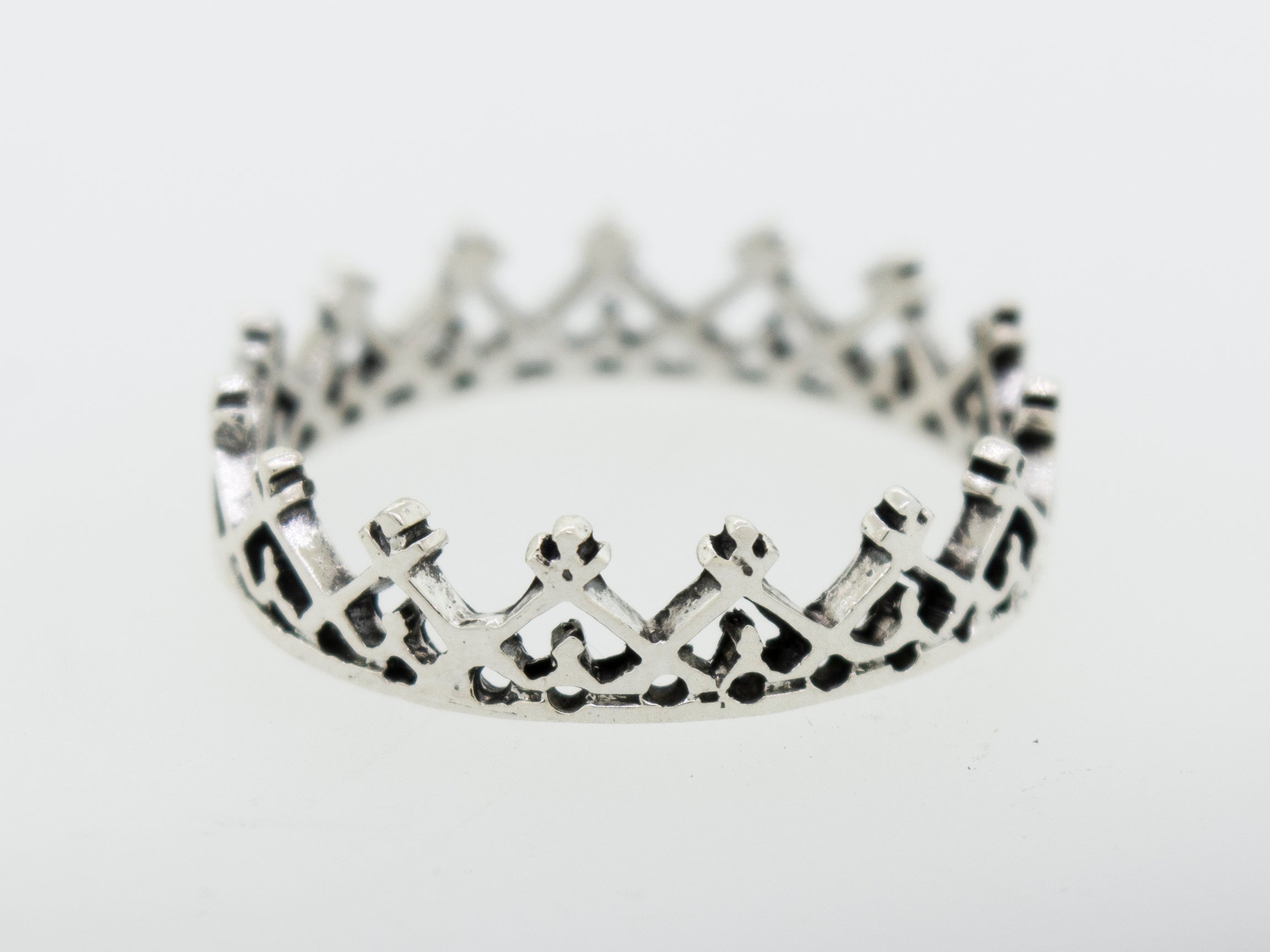 A Super Silver silver crown ring with freestyle design on a white surface.
