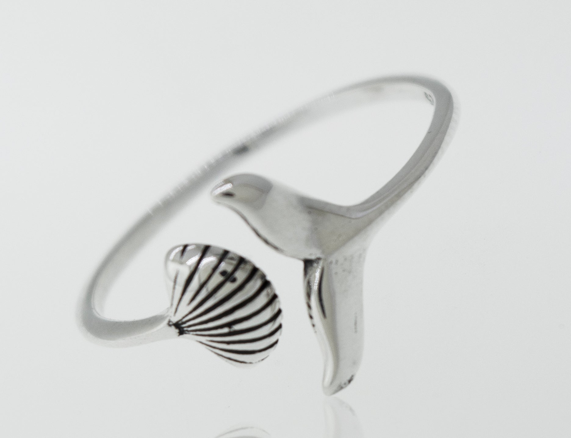A Shark Tail and Seashell Ring from Super Silver with a seashell on it.