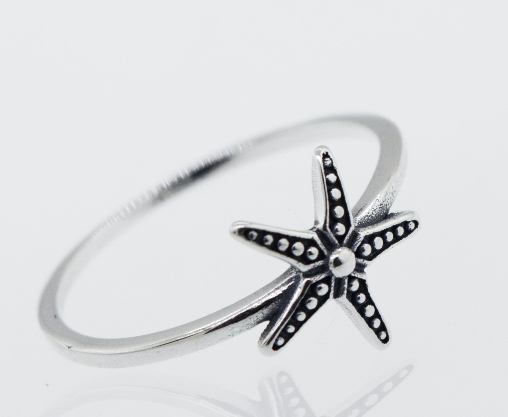 An oxidized Super Silver starfish ring on a white background.