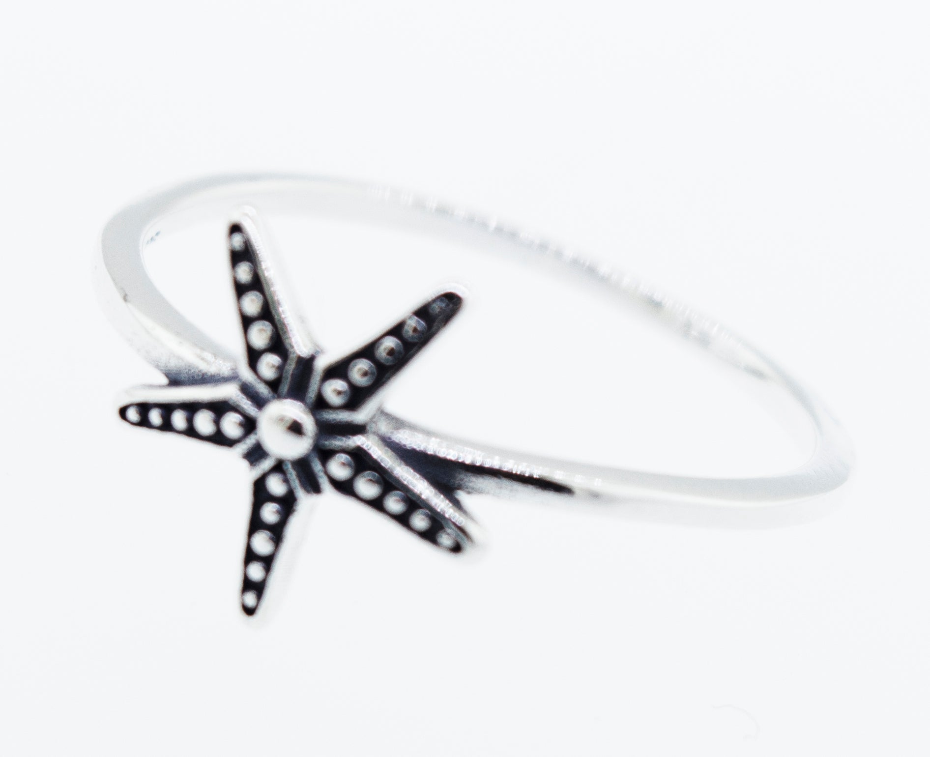 An oxidized Super Silver starfish ring on a white background.