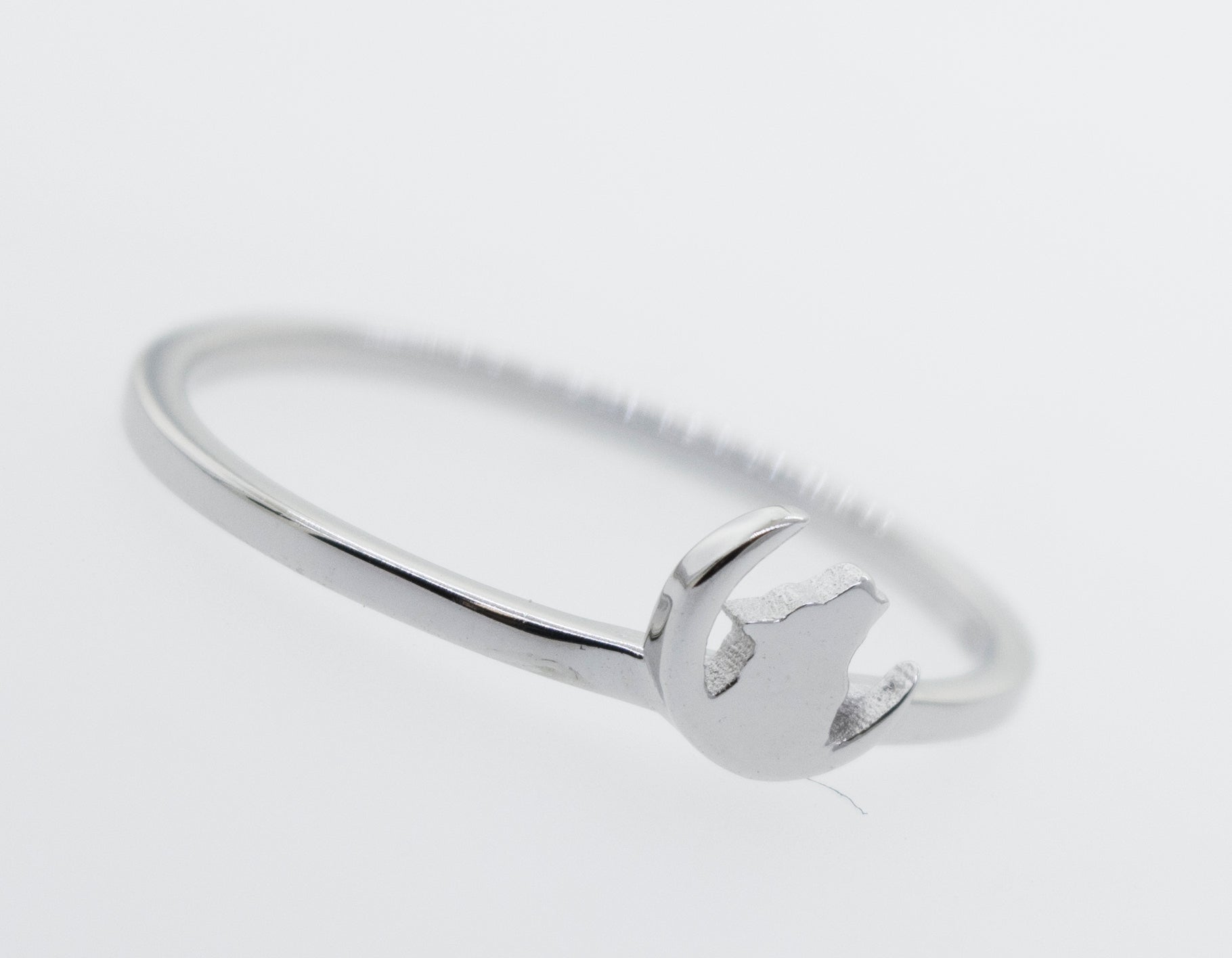 A Howling Wolf On Crescent Moon Ring by Super Silver with a small heart on it.