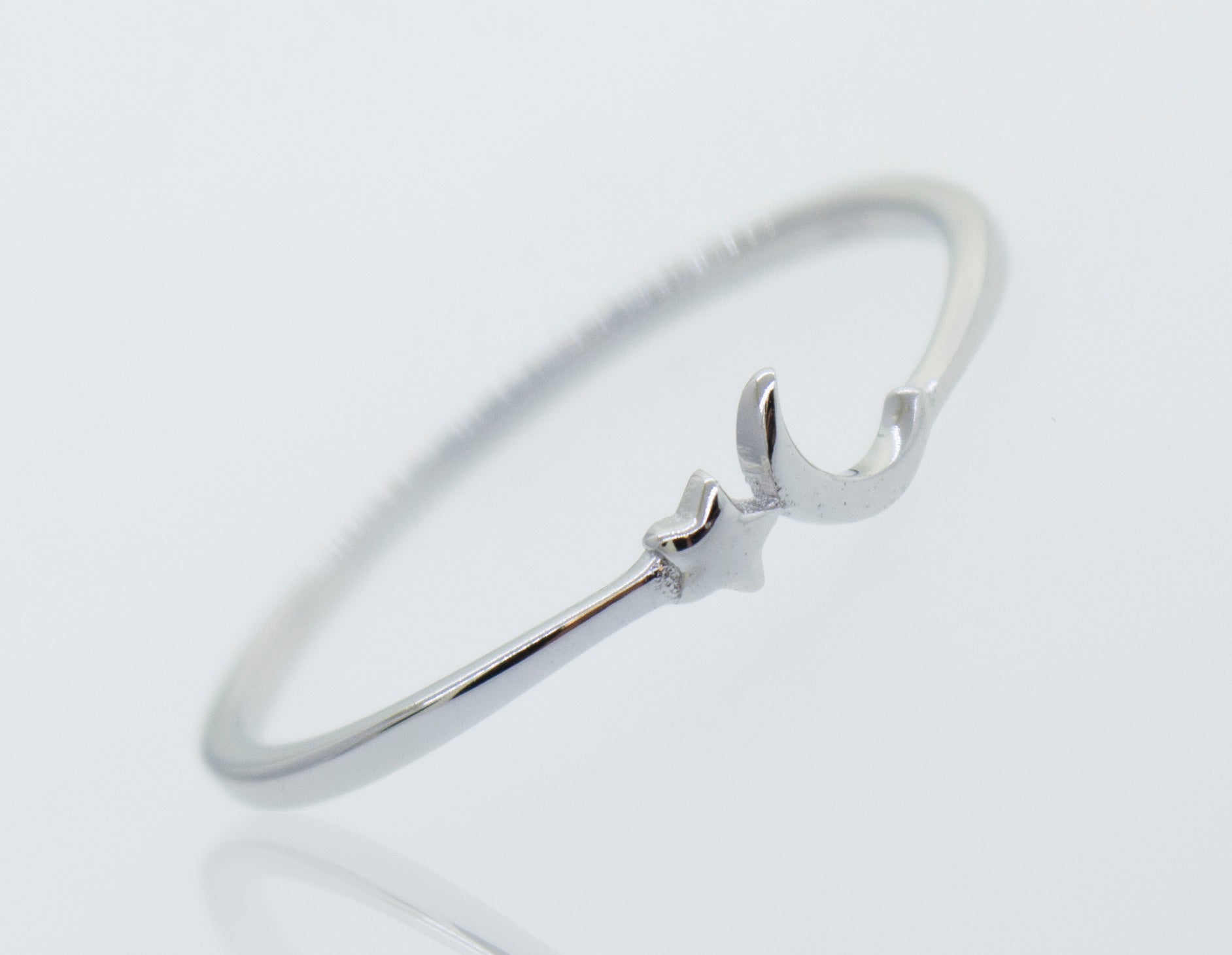 A Super Silver Star And Crescent Moon Ring with a small heart on it.