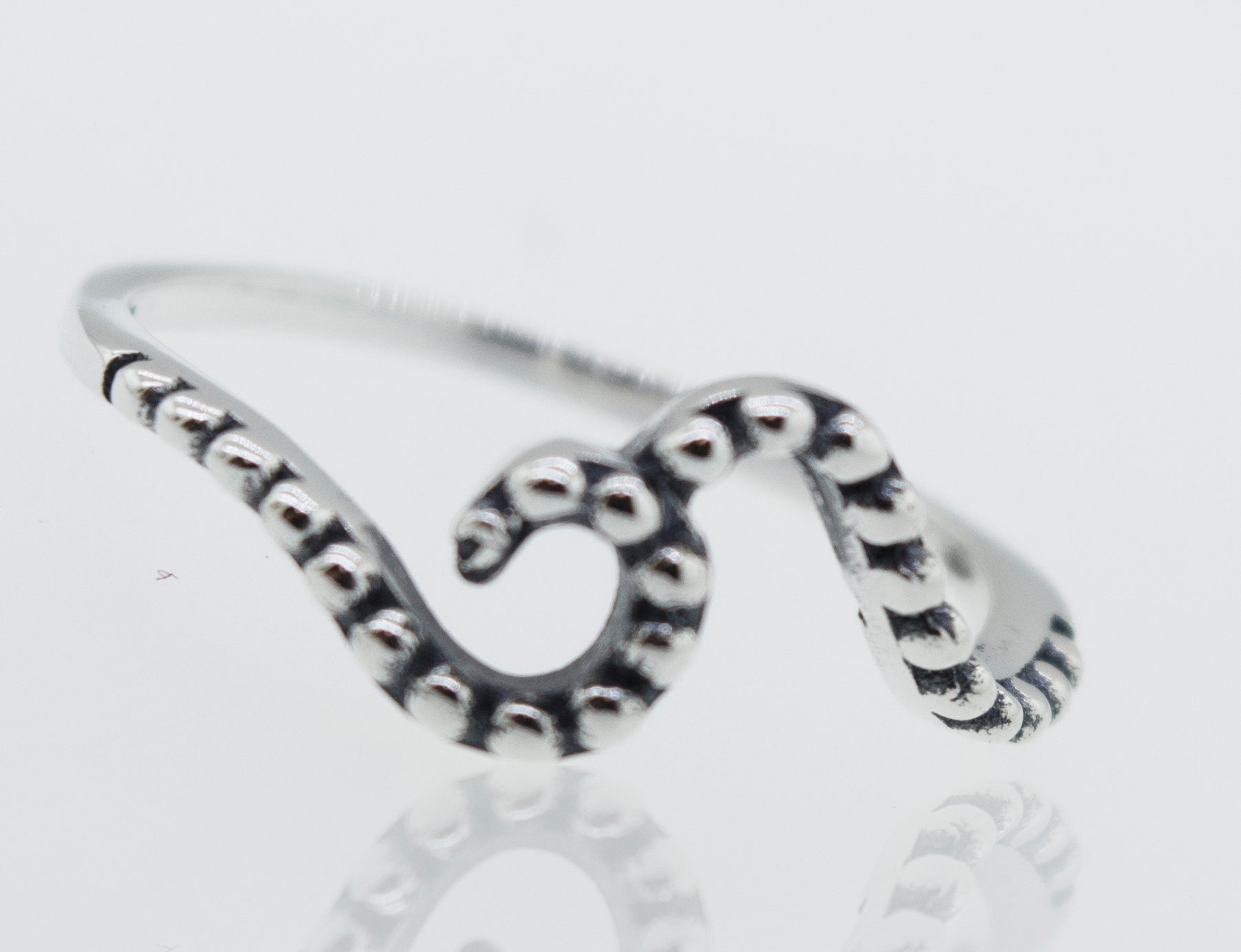 A Dotted Wave Ring sterling silver octopus ring on a white surface.