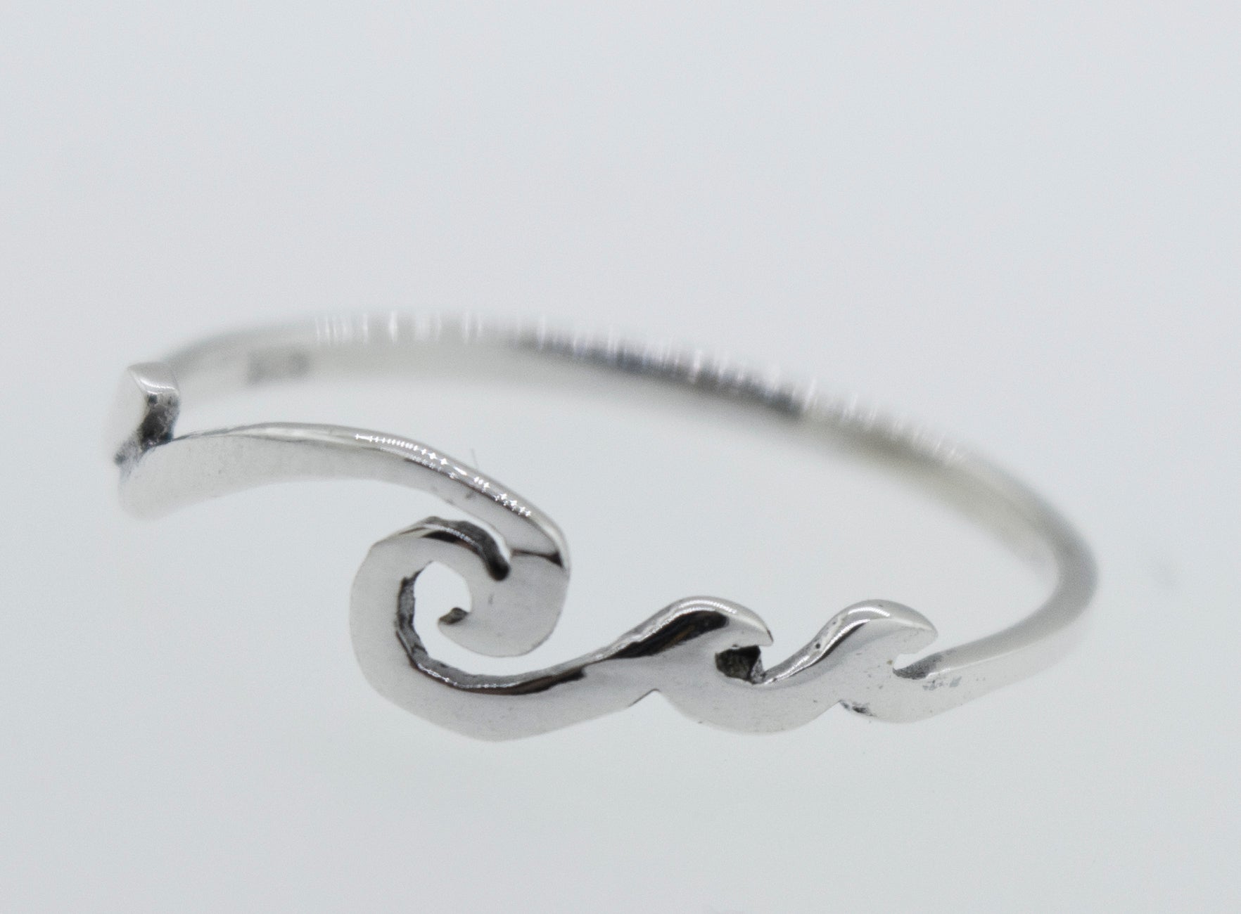 A modern sterling silver Wave Ring with a minimalist wave design.