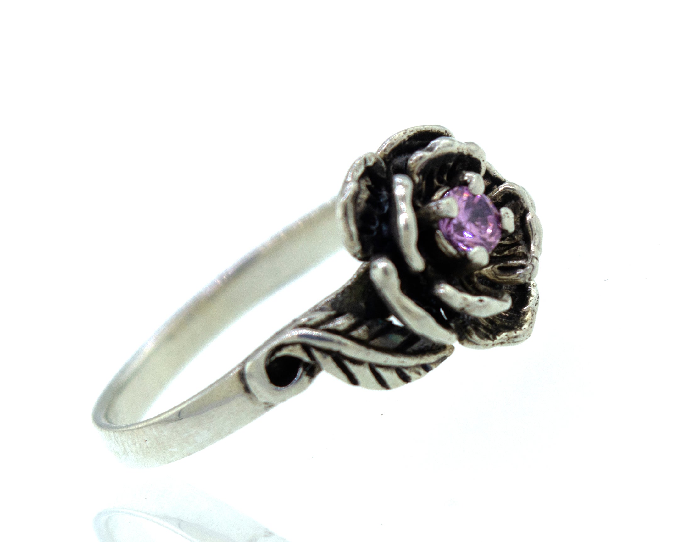 A sterling silver ring with a rose-shaped design features a small purple gemstone at the center, showcasing the elegance of a Rose Ring With Cubic Zirconia Stone.