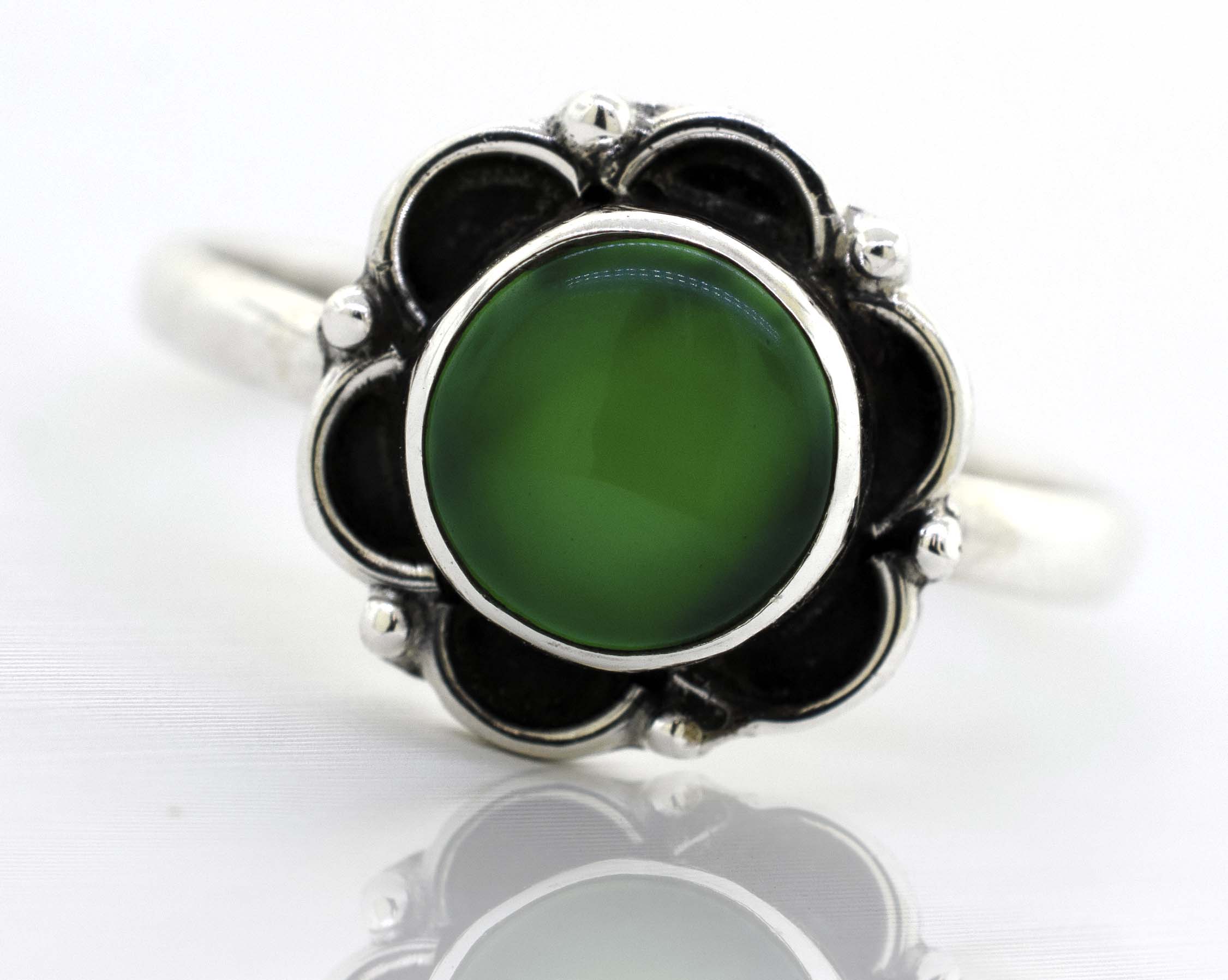 A Gemstone Ring With Oxidized Flower Design with a green stone and black stones.