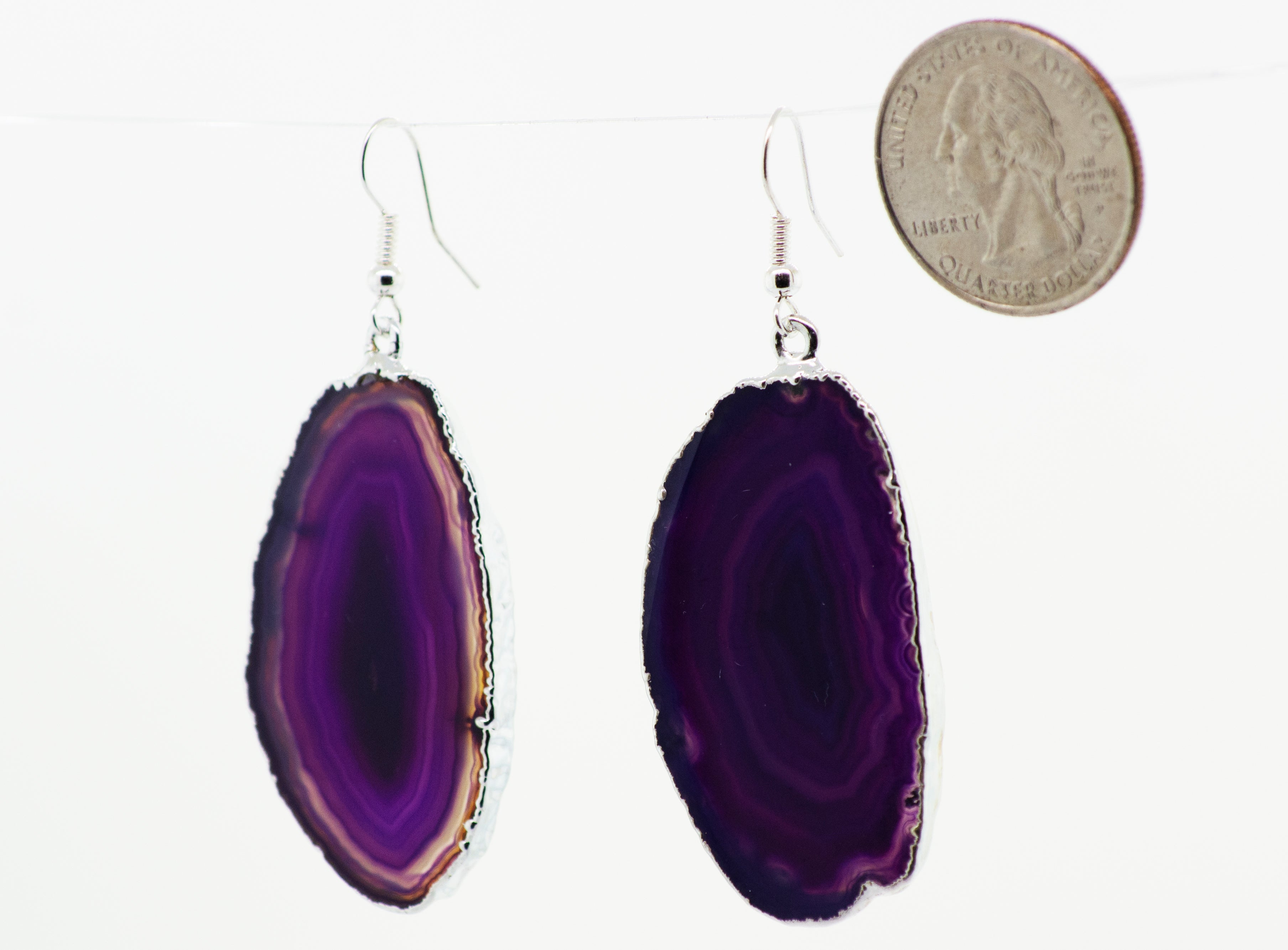 A purple Dyed Agate Slice Earrings hanging from a string with a Super Silver-plated border.
